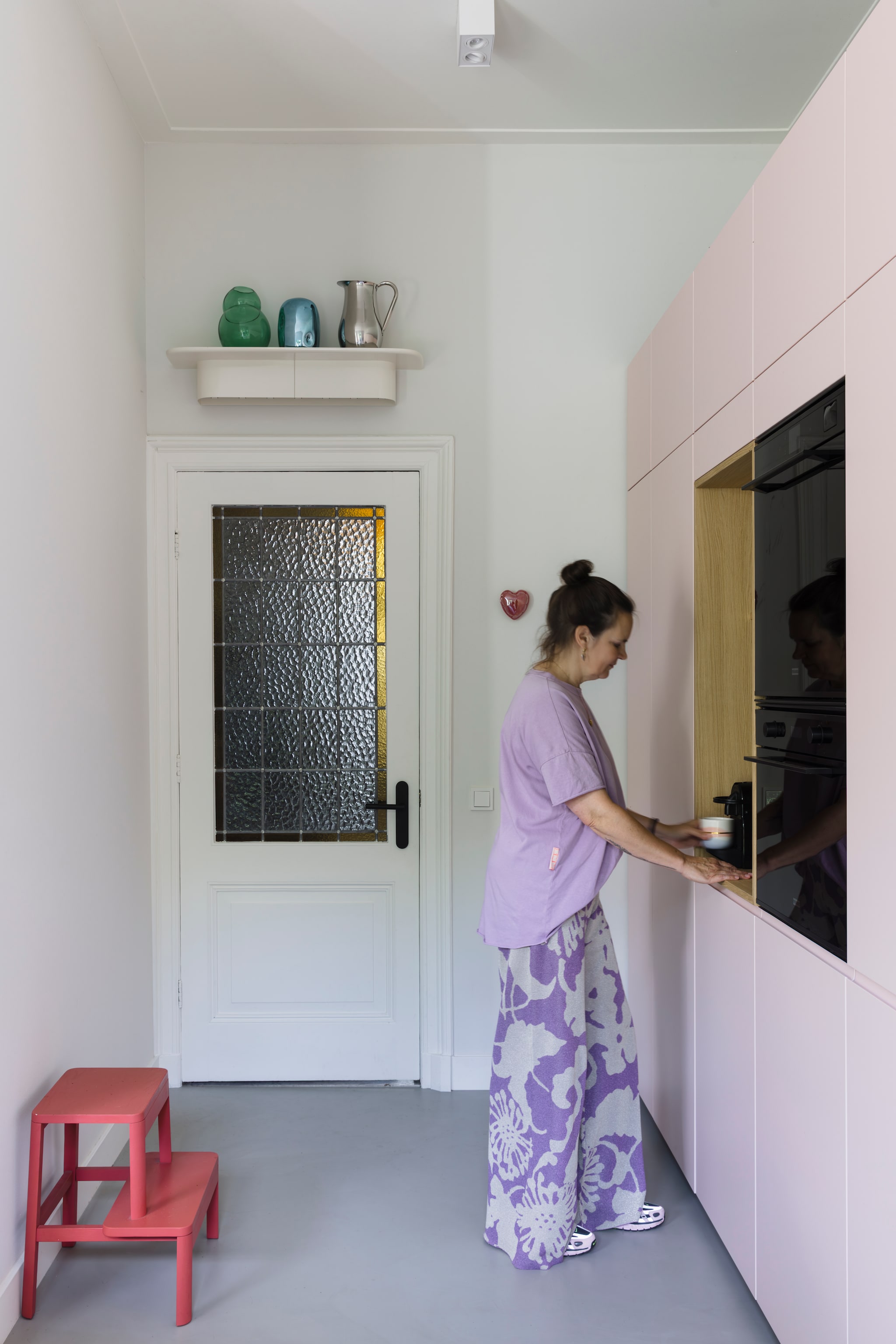 Maatwerk keuken Houtmerk. Wandplank en chromen karaf Hay. Groene vaas Klaas Kuiken. Blauwe vaas HKliving. Keramieken hart Laulabel via Prchtg. Kruk Arise Stool van Million. Gietvloer via aannemer. vtwonen 05-2026 | styling stylestek | fotografie Eva bloem