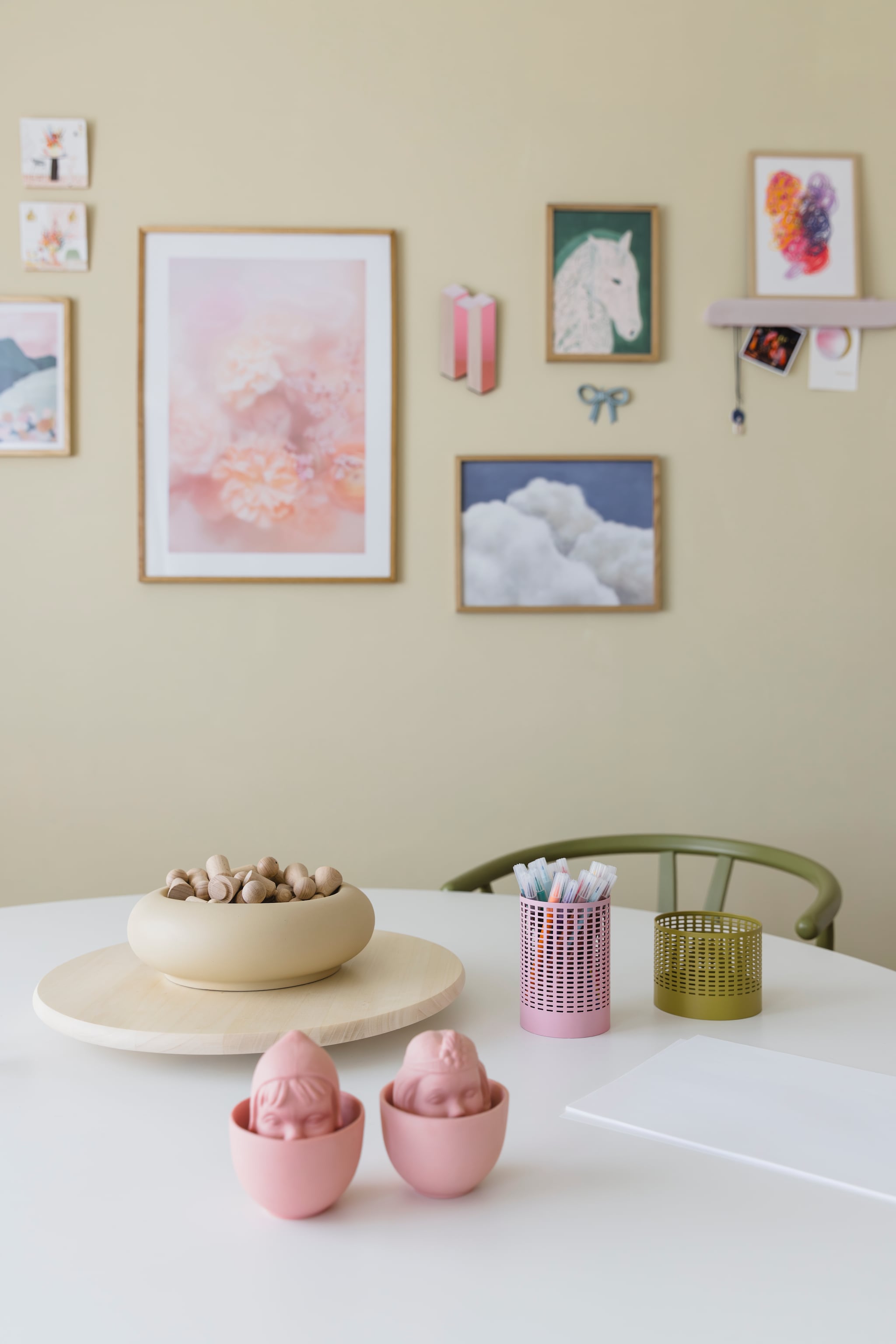 Gele schaal H&m. Roze keramieken kopjes Kopje Kopje van Studio Rens en Tegels Storytiles via Prchtg. Bakjes Ikea. Wandplank Studio Harm en Elke. Print Rogier Roeters. Overige prints Desenio. Strik Søstrene Grene. vtwonen 05-2026 | styling stylestek | fotografie Eva bloem