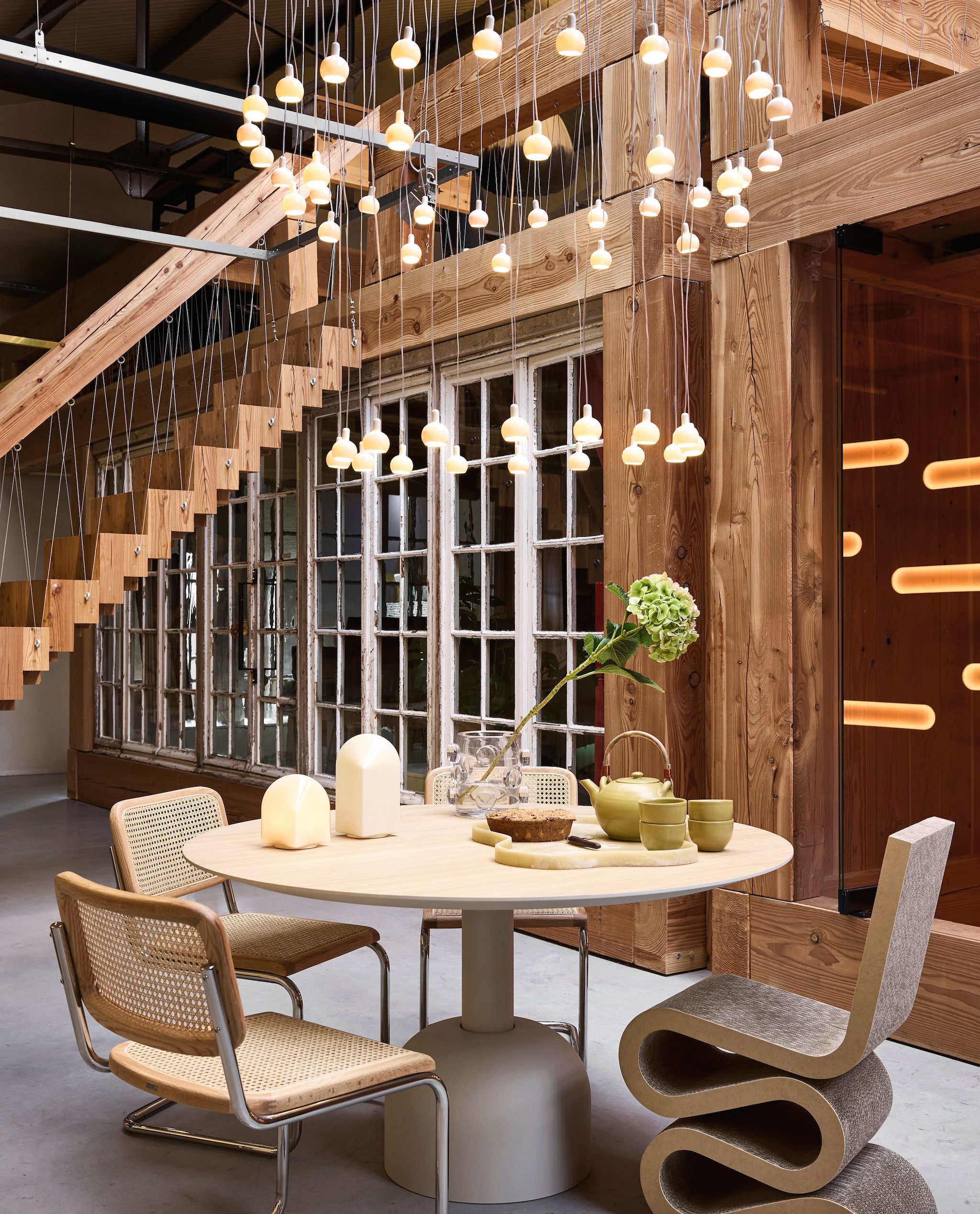 Piet Hein Eek lamp, keramiek, porselein, wit vanaf € 295,- tot€ 3000,-, Marjan van Aubel lichtobject Sunne, messing, veelkleurig, op zonne-energie, prijs op aanvraag (vanmokum.com). Hay draagbare lamp Parade, glas, schelpenwit, vanaf € 160,- (hay.com). J-line vaas Pebbles, glas, transparant, small, 21,5 cm (Ø) € 110,50, HKliving dienblad Patio, polyhars, marmer crème, groot € 189,- (shop.vtwonen.nl). Miniforms eettafel Illo, eikenhout, 140x75 cm (Øxh) € 2269,-, Vitra stoel Wiggle Side, golfkarton € 1060,-, eetkamerstoel Claery, riet, metaal, beige € 250,- (loods5.nl). Atelier Sukha theepot Olive, klei, groen € 60,-, schaaltje, keramiek, groen € 10,- (sukha.nl). vtwonen 02-2026 | styling Marianne Lunning | fotografie Alexander van Berge