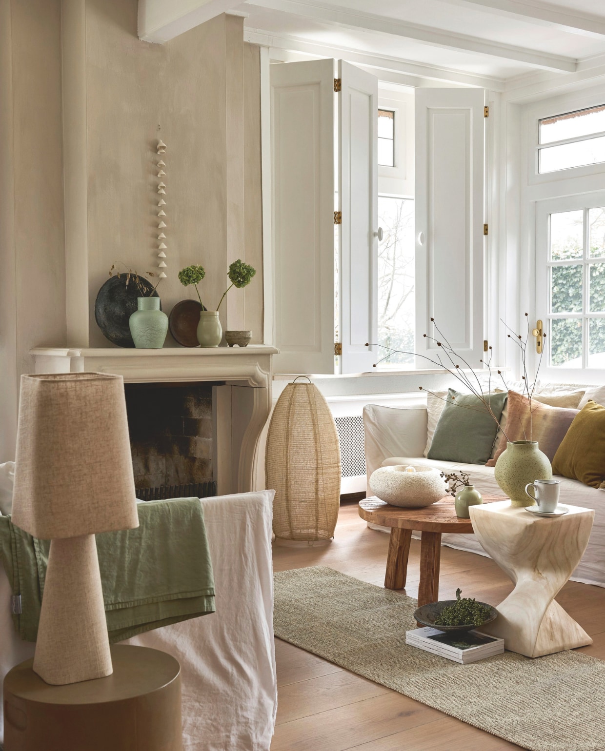 Urban Nature Culture vaas Heron, keramiek, green bay € 62,99, vaas Brisa, keramiek, lichtgroen € 54,99, tafellamp Izumi, keramiek, wit, 31,5x14 cm (Øxh) € 99,-, Light & Living tafellamp Mikko, linnen en hout, naturel, 20x20x58 cm (bxdxh) € 74,99, bijzettafel Muhan, hout, bruin, 30x30x45 cm (bxdxh) € 179,-, Raw Materials schalen Volcan, keramiek, grijs, set van 3 € 84,95, salontafel Farmwood, hout, 70x38 cm (Øxh) € 445,- (shop.vtwonen.nl). Gervasoni bank Ghost 14, stof, lino bianco, 260x85x80 cm (bxdxh) € 4295,- (gervasoni1882.com). Designers Guild kussen Brera Arte, linnen € 180,- (wva.nl). Bonsoirs kussen, fluweel, brons € 40,-, kussen, fluweel, zachtgroen € 40,- (bonsoirs.com). Nordic Sand mok met oor € 12,-, gebaksbord € 12,- (brostecopenhagen.com). Zara Home vloerlamp, linnen en metaal, ecru € 89,99, pot, aardewerk, groen € 22,99, vloerkleed, sisal, lichtbeige € 99,99 (zarahome.com). Karwei bijzettafel Fay, zandkleurig 34x40 cm (Øxh) € 74,99 (karwei.nl). Overig privébezit. vtwonen Landelijk | styling Sanne Ketelaar | fotografie Alexander van Berge