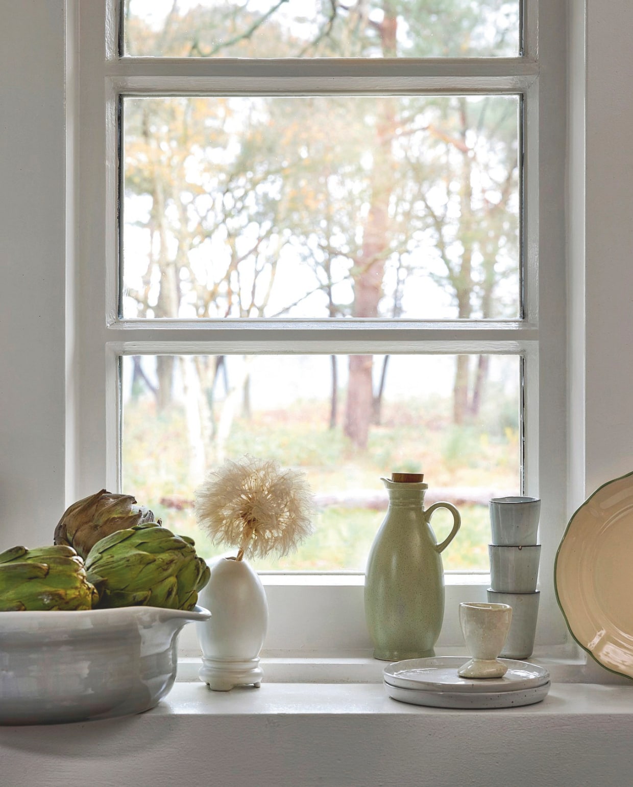 Zara Home oliefles met deksel, aardewerk, groen € 17,99 (zarahome.com). Nordic Sand gebaksbord € 12,-, espressomok € 8,- (brostecopenhagen.com). Serax eierdop Out of Lines, aardewerk, gebroken wit € 10,50 (serax.com). H&m Home ontbijtbord, keramiek, beige € 9,99 (hm.com). Overig privébezit. vtwonen Landelijk 02-2026 | styling Sanne Ketelaar | fotografie Alexander van Berge