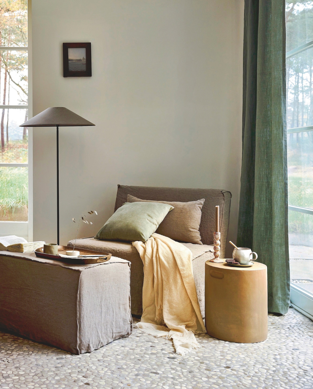 Aura Peeperkorn fauteuil Lalinde, taupe, 90x80x80 cm (bxdxh) € 745,-, poef Lalinde, taupe, 90x45x45 cm (bxdxh) € 395,-, snijplank, hout € 33,-, vloerlamp ronde buis, zwart, 120 cm (h) € 135,-, lampenkap Chinees, linnen, polo herfst € 143,30, fotolijst, hout € 42,50 (aurapeeperkorn.com). Designers Guild gordijn, linnen Brera Lino, groen, per meter € 105,- (wva.nl). Bonsoirs kussen, fluweel, kakigroen € 40,- (bonsoirs.com). UrbanNature Culture kandelaar Sisi, keramiek, bruingespikkeld € 19,99 (shop.vtwonen.nl). KenkawaiJapanse wierookhouder, beton, grijs € 49,- (kenkawai.com). Dille & Kamille mok, steengoed, grijs € 8,50 (dille-kamille.nl). Karwei bijzettafel Fay, klei, zand, 34 cm (Ø) € 74,99  (karwei.nl). Zara Home geurkaars Neroli, groen € 15,99, serveerblad, hout € 29,99, deken, wol, ecru € 79,99, dessertbord, porselein, groen € 6,99 (zarahome.com). Overig privébezit. vtwonen Landelijk 02-2026 | styling Sanne Ketelaar | fotografie Alexander van Berge