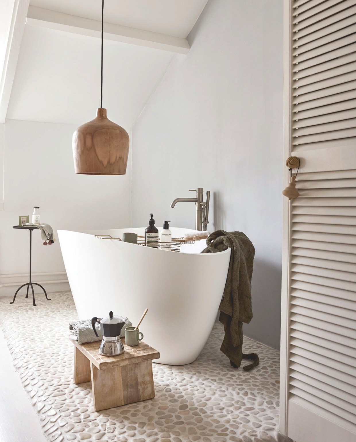 Raw Materials kruk Chiseled Top, hout, naturel, 40x25x20 cm (bxdxh) € 55,95, lamp Sirocco Bottle, hout, 25x28 cm (Øxh) € 145,- (shop.vtwonen.nl). Dille & Kamille percolator, aluminium, rvs € 54,95 (dille-kamille.nl). Zara Home bijzettafel, verouderd metaal, zwart € 79,99, badhanddoek, katoen bloemenjacquard, groen € 12,99, badjas, katoen, bruingrijs € 59,99, badhanddoek pompons, katoen, groen € 6,99, mok antieke rand, porselein, groen € 3,99, Neroli geurkaars € 15,99 (zarahome.com). Aesōp shampoo € 49,- (skins.nl). Marie Stella Maris bodywash Nº12 Objets d’Amsterdam € 20,- (marie-stella-maris.com). Overig privébezit. vtwonen Landelijk 02-2026 | styling Sanne Ketelaar | fotografie Alexander van Berge