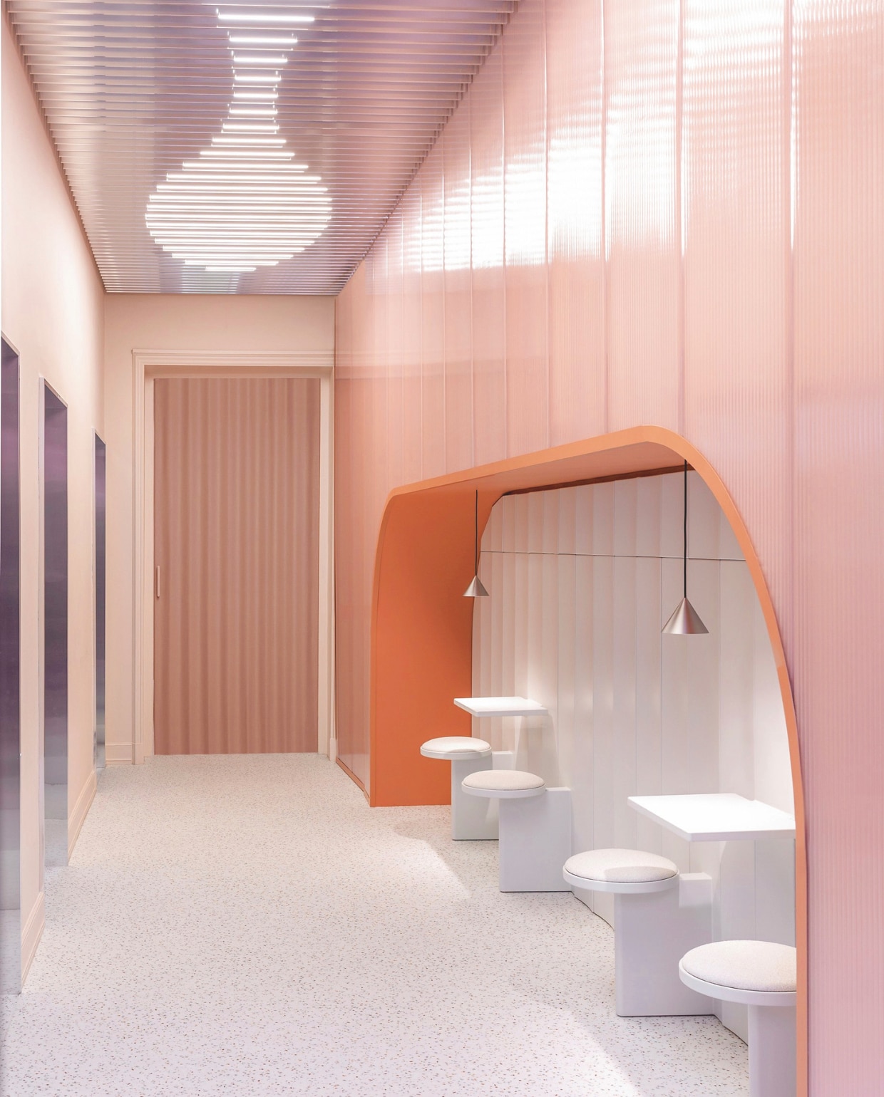 Decoratieve wandbekleding in nis Posa Slab van Pulkra. Daarboven polycarbonaat honingraatpanelen PanelPiù 500/40 14P van PolyPiù. Stoel en tafel Posa van Pulkra. Hanglampen Apollo Zero van Pholc. Vloer Taralay Impression Compact van Gerflor. Aluminium panelen Dresswall Stripes van Dresswall. Deur van textiel Lateral opening door van Dooor. vtwonen Design 01-2026 | styling Studiopepe | fotografie Filippo Ferrarese & Silvia Rivoltella