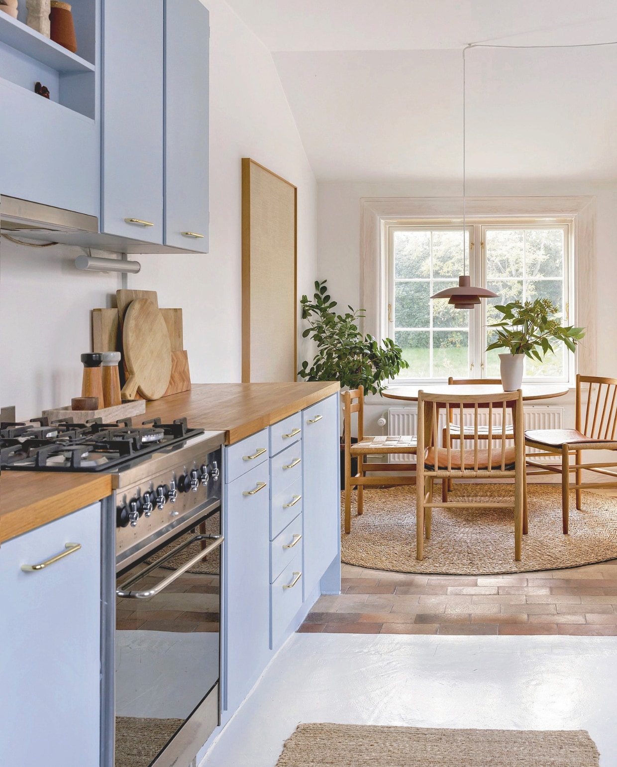 Originele keuken. Muurkleur Nordic Breeze van Jotun, vergelijkbare tint Jackie Blue van Lab Paint. Tafel No78. Stoelen Jørgen Bækmark. Peper-en-zoutstel Normann Copenhagen. Hanglamp Louis Poulsen. vtwonen 02-2026 | styling Rikke Graff Juel | fotografie Christina Kayser O.