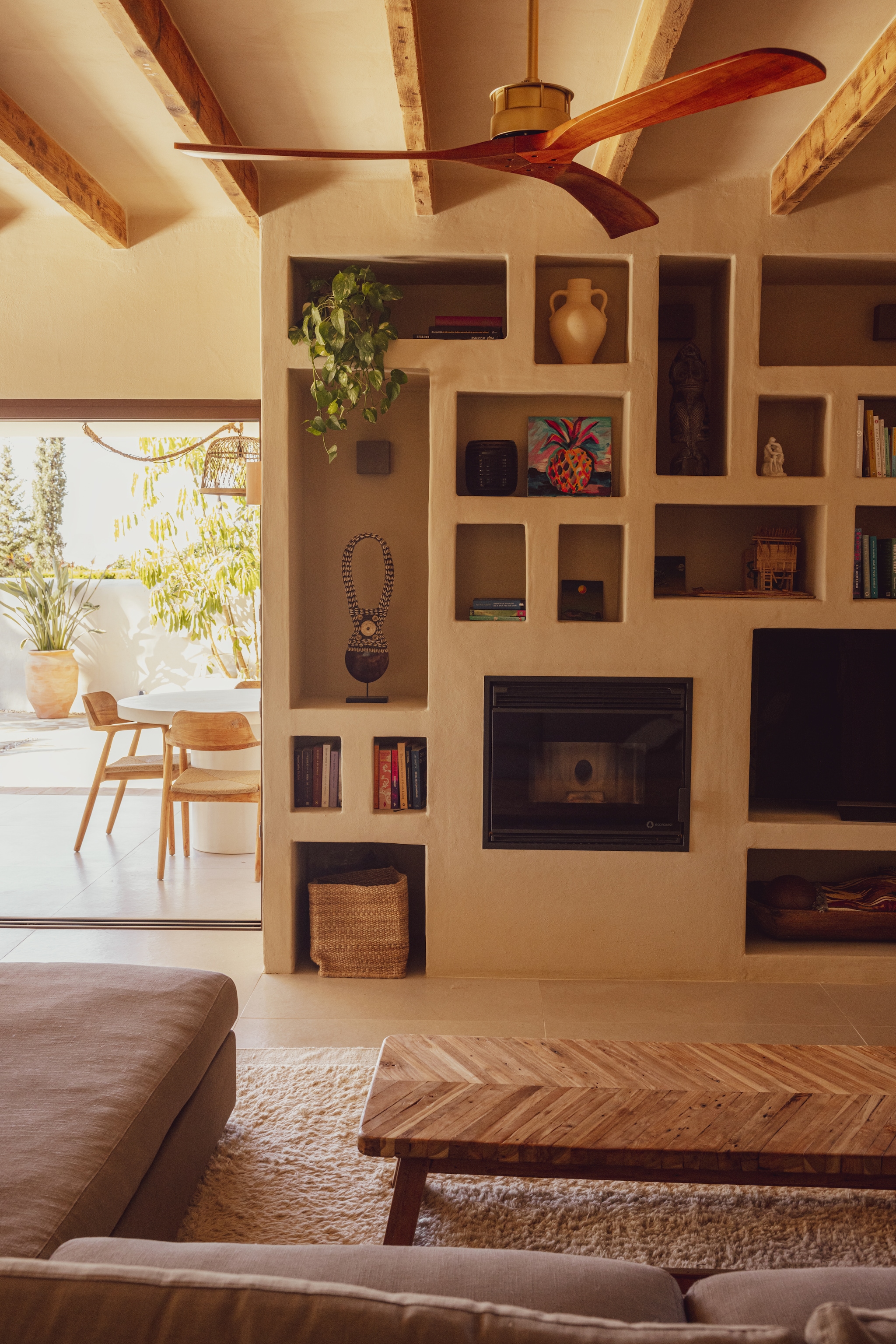 Bank Linteloo. Vloerkleed uit Marokko. Salontafel Azurée Javea. Buitentafel Kave Home. Buitenstoelen Ibiza Outdoor. In de kast boeken, lokale keramiek, kunst uit Afrika en Bali, en zelfgemaakte schilderijtjes. vtwonen special 02-2026 | styling en fotografie Dana van Leeuwen | productie Dana Photo and Film