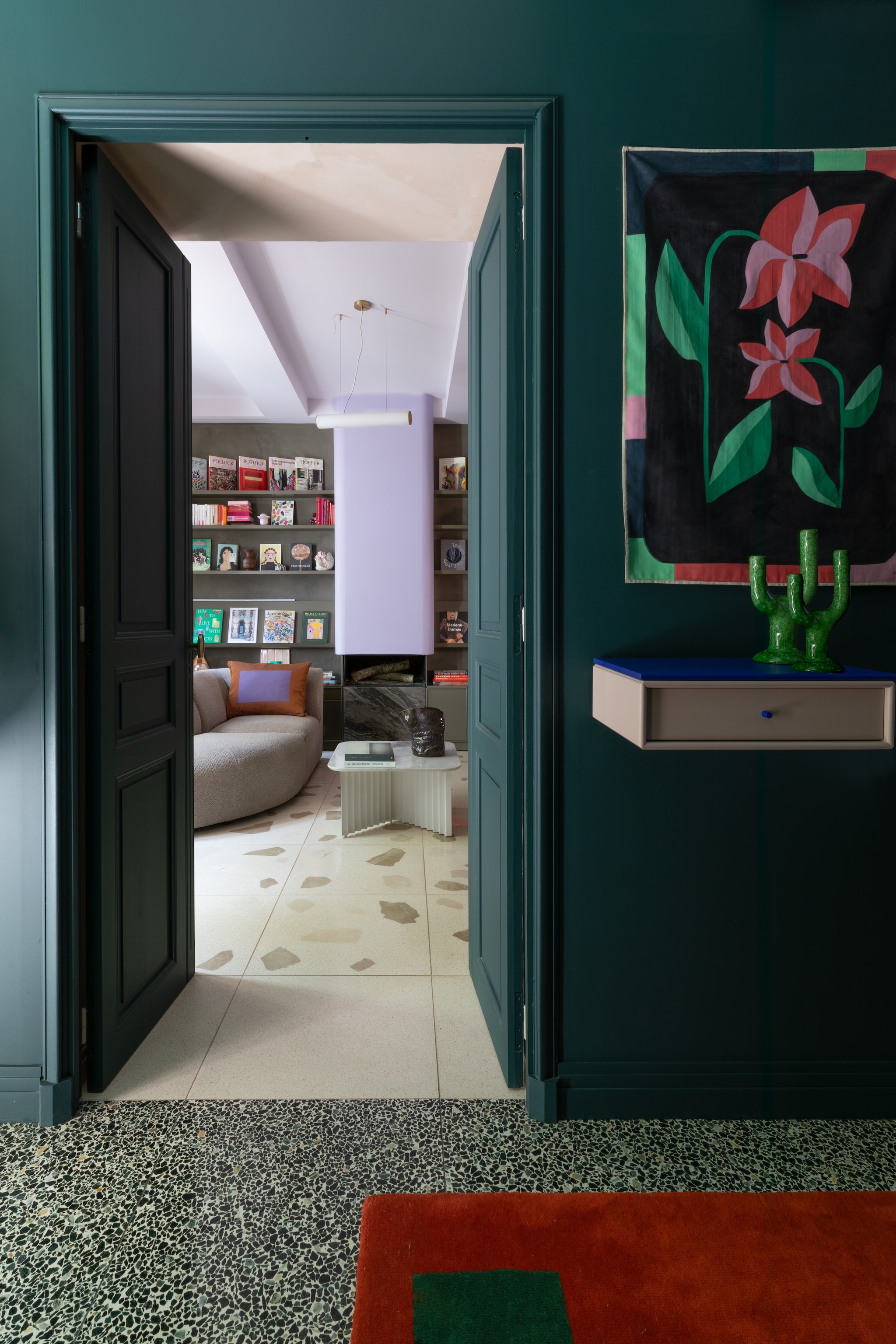Terrazzovloer in de woonkamer ontworpen door Marine. Modulaire wandkast ontworpen door Marine voor Montana Furniture. Kunstwerk Pauline Desombre. Kandelaars HKliving. Vloerkleed Solange van ColorTherapis. vtwonen Design 05-2026 | styling Francesca Sironi | fotografie Monica Spezia | productie Living Inside