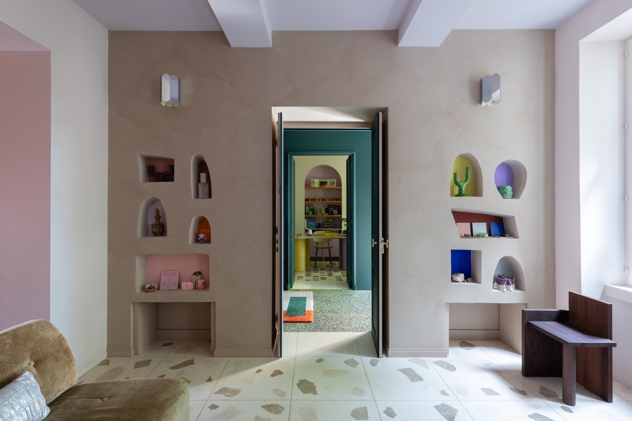 Uta Piece Stool van Ferm Living. In de wandnissen unieke keramische objecten van Maison Mavi. Wandlamp Arcs van Muller Van Severen voor Hay. Terrazzovloer ontworpen door Marine. Muur geschilderd in duifgrijs van Ressource Peintures. vtwonen Design 05-2026 | styling Francesca Sironi | fotografie Monica Spezia | productie Living Inside