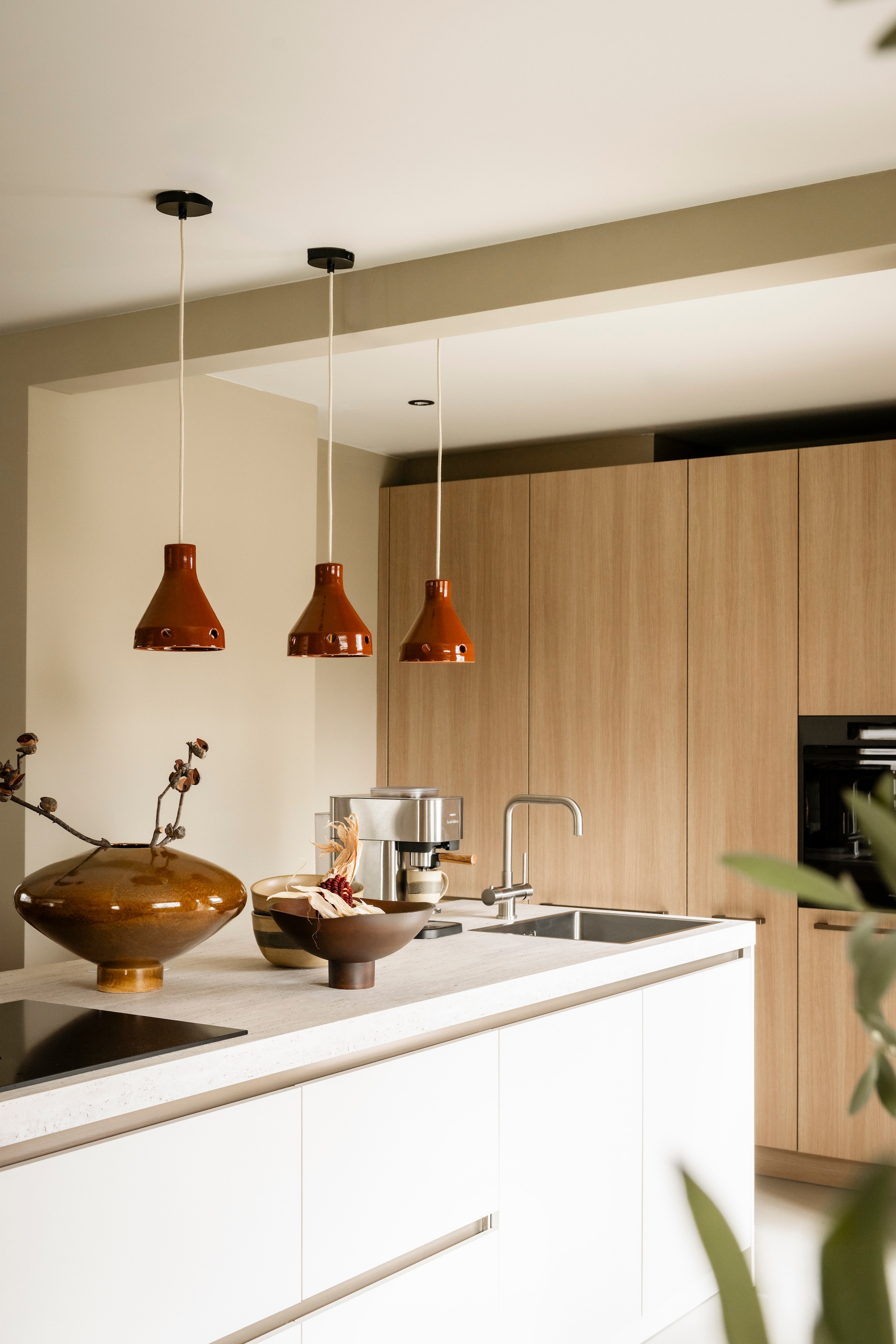Vloer vtwonen Marmoleum Basic truffle vtw120 met vloerverwarming Aanhuis. Keuken met 2 kleur fronten hoge kasten in eiken urban, ⁠eiland in sarah beige, ⁠⁠werkblad in travertino Mandemakers. Hanglamp Terra van Household Hardware vtwonen shop. Overige productinformatie via https://www.vtwonen.nl/weer-verliefd-op-je-huis/aflevering-7-liza-veenendaal-resultaat~0bbcc8c.