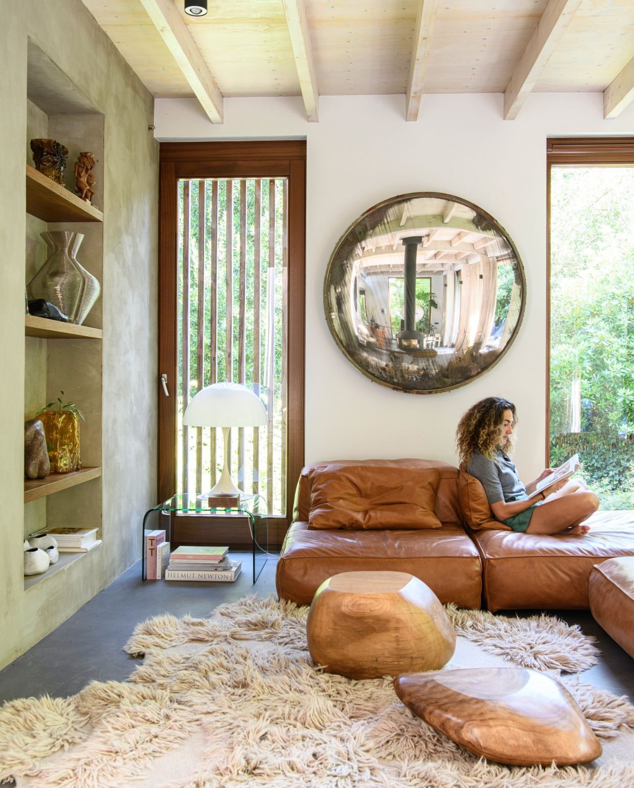 Kleur muur ral 9016. Bank Living Divani. Vintage Poolse verkeersspiegel. Glazen tafel Fiam. Tafellamp Verner Panton. Salontafels Mija. Vloerkleed Cappelen Dimyr. Amberkleurige vaas Nicolas Erauw. Keivormige vazen Cor Unum. Grote vaas Dirk van der Kooij. Afrikaanse beelden van ouders van Cees. vtwonen 03-2026 | styling Marit Saladini | fotografie Louis Lemaire