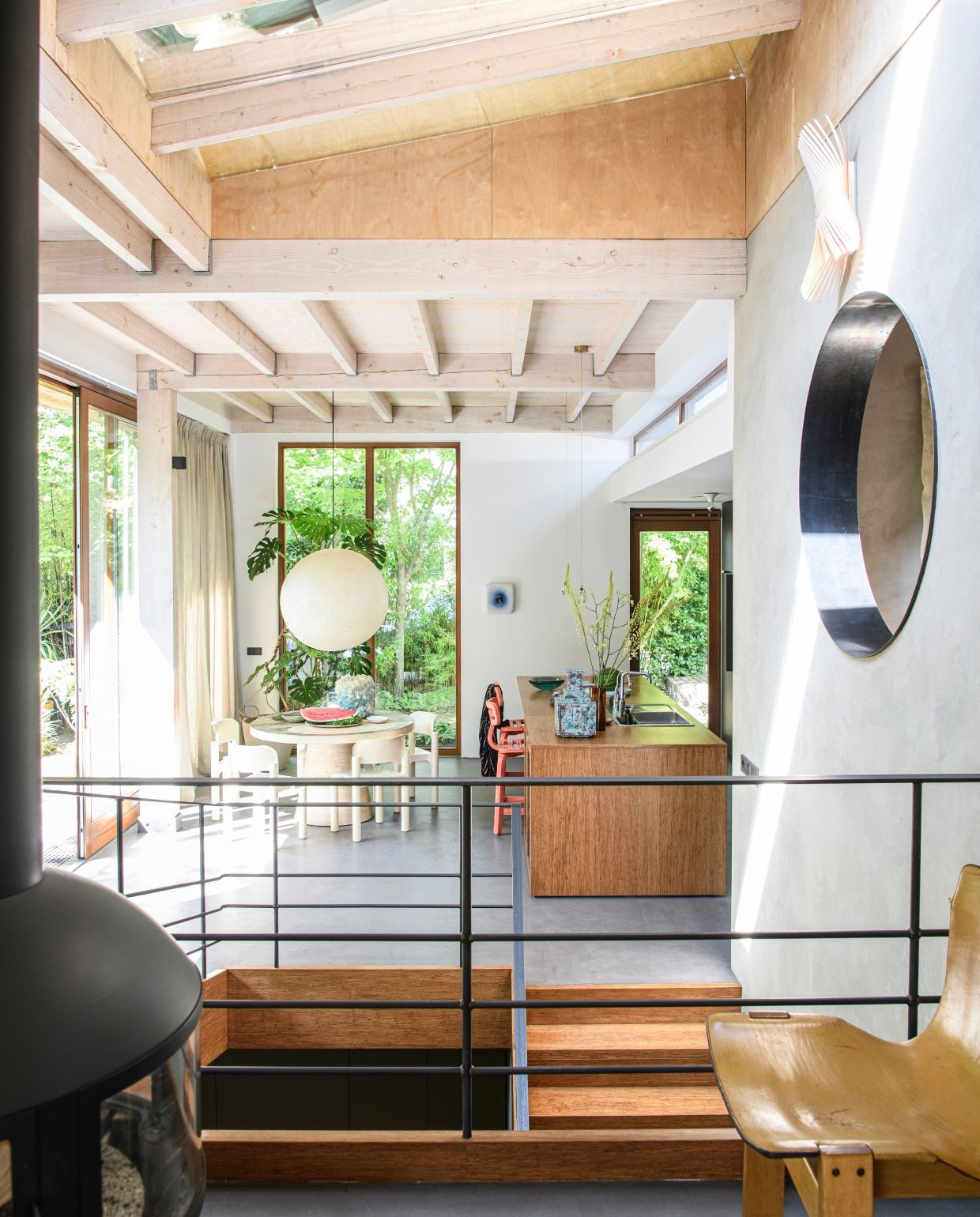 Pandomo cementvloer. Keuken maatwerk door meubelmakerij Het Woud. Eettafel Jacqueline le Bleu. Vintage stoelen Eero Aarnio voor Upo Furniture. Hanglamp vintage. Vaas Isaac Monté. Barkrukken Dirk van der Kooij. Vaas op keukeneiland Studio Fabius Clovis. Keramieken kunstwerk Wil van Blokland.