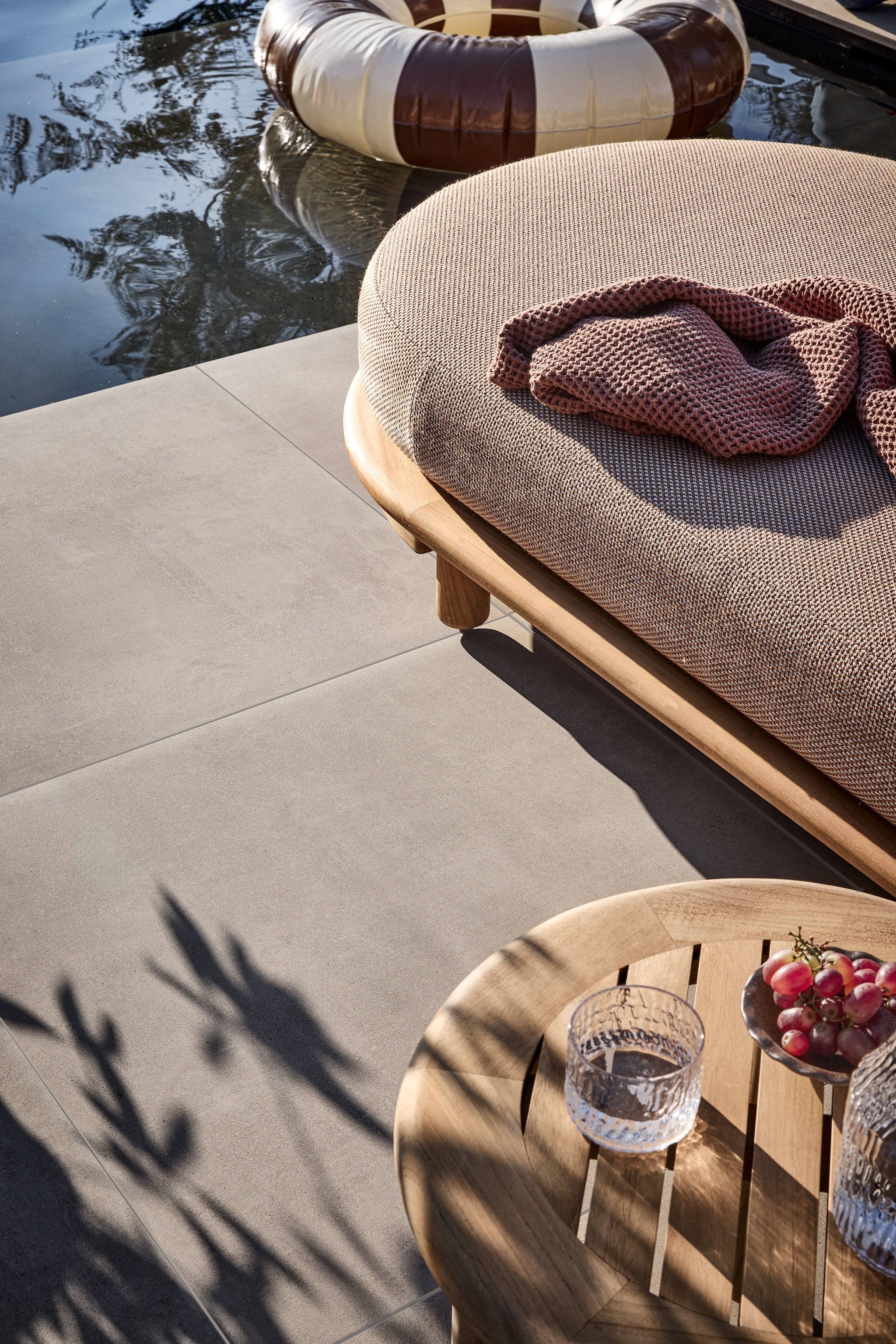 vtwonen tuintegel Beton, keramiek, olive, 80x80 cm, per m² € 76,-.M.m.v. zarahome.com (handdoek), borek.eu (chaise longue Bassano). vtwonen 04-2026 | styling Kim van Rossenberg | fotografie Peggy Janssen