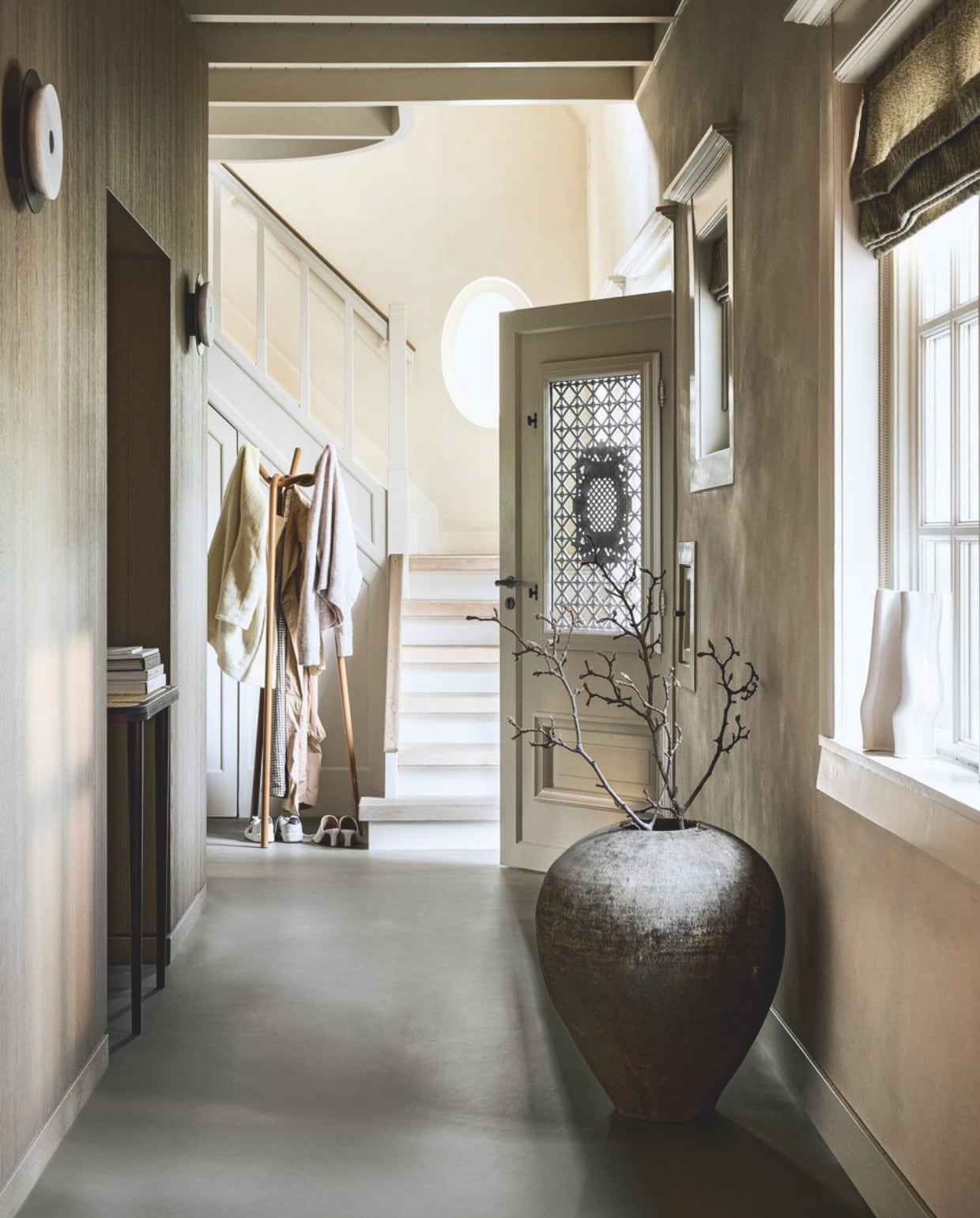 vtwonen Marmoleum Basic, cement, 200 cm breed, per m² € 53,80M.m.v. hay.nl (kapstok), fermliving.com (witte vaas), loods5.nl (antieke vaas). Overig privébezit. vtwonen Landelijk 02-2026 | styling Kim van Rossenberg | fotografie Sjoerd Eickmans