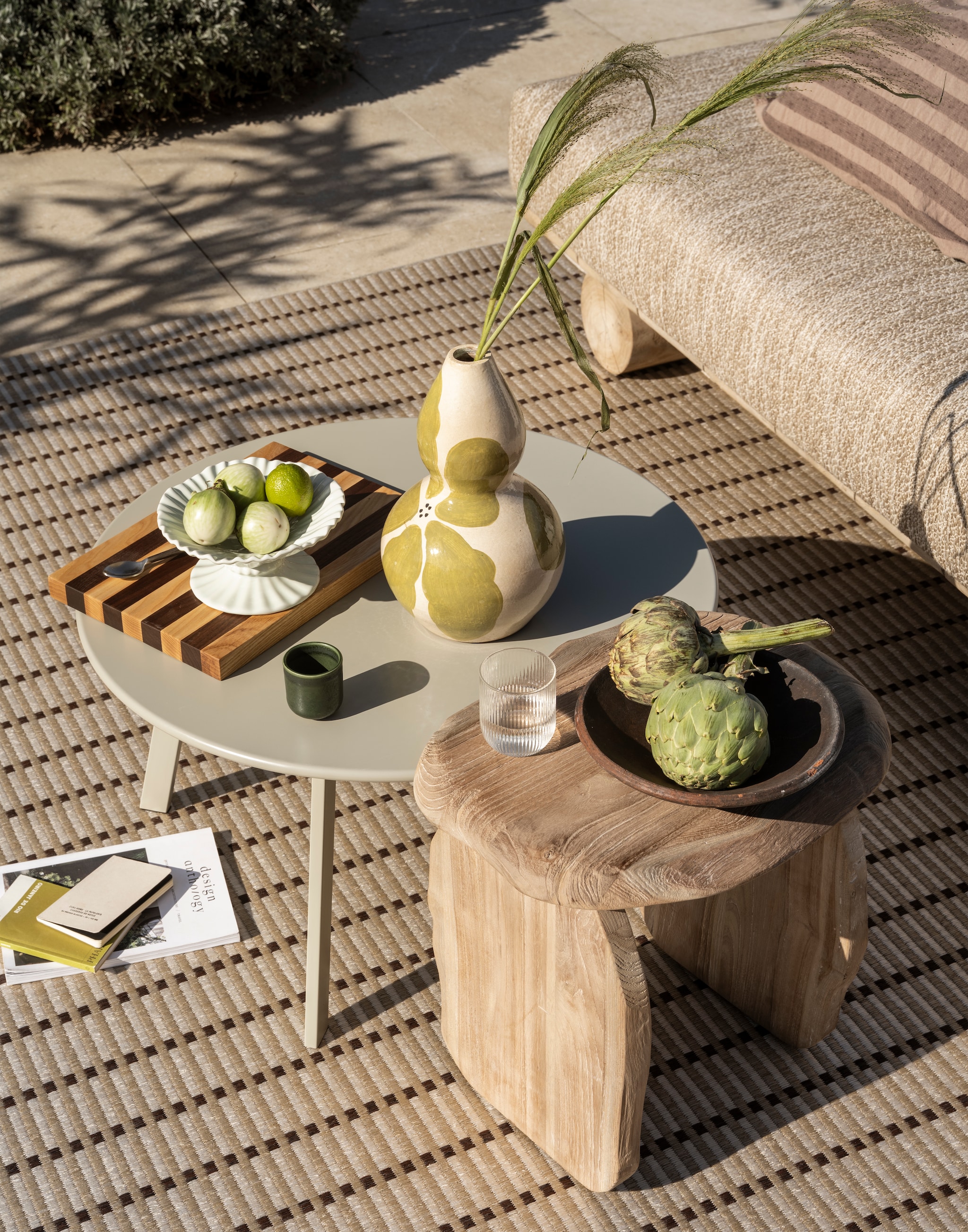 Gommaire bank Sofa Edge, teakhout, naturel, 240x100x70 cm (lxdxh) € 3475,-, kussenset Sofa Edge, outdoor stof en sneldrogend schuim, beige en grijs € 2735,- (gommaire.com). Ferm Living snijplank Stripe Bold, walnoot en eikenhout, naturel en bruin € 139,- (fermliving.com). Karwei buitenvloerkleed Kawasaki, naturel, 230x160 cm (lxb) € 81,75 (karwei.nl). HKliving schaal op voet New Classics, aardewerk, lichtblauw, 20 cm (Ø) € 44,95 (hkliving.com). Zara Home vaas met bloemen, terracotta, groen € 39,99, kussenhoes, katoenmix, bruin € 39,99, (zarahome.com). H&m Home espressokopjes, keramiek, groen, set van 4 € 19,99 (hm.com). Overig privébezit. vtwonen Special 02-2026 | styling Sanne Ketelaar | fotografie Stan Koolen