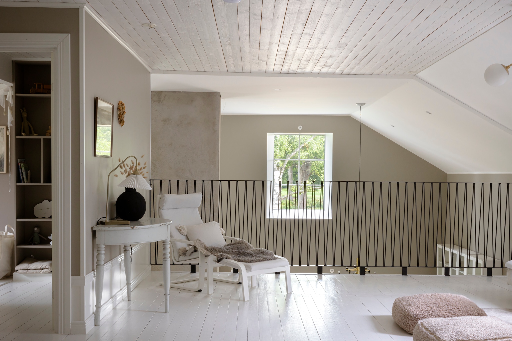 Behang Linen Beige 4315 van Boråstapeter. Vloer origineel. Hekwerk zelf gemaakt. Bijzettafel en vaas vintage. Lamp en kussens Lilla Stenhuset. Fauteuil Ikea. vtwonen Landelijk 06-2026 | styling Anna Bjelkholm | fotografie Anna Karlsson