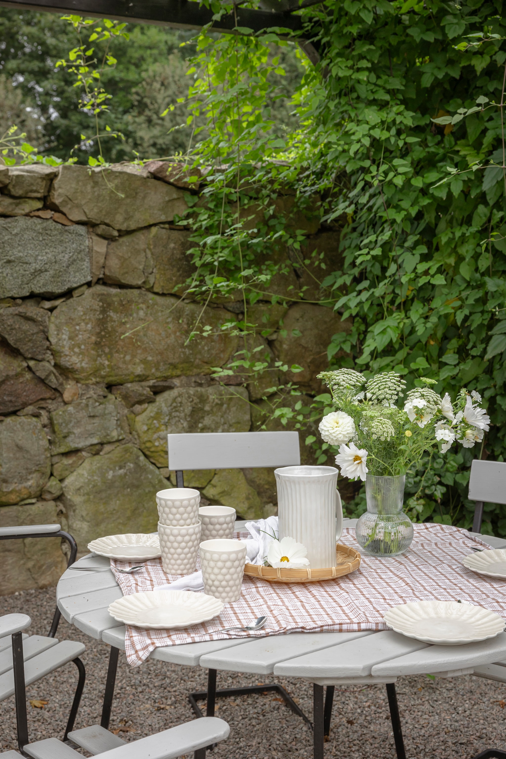Servies en rieten schaal kringloop. Borden en mokken Mateus. Vaas Ikea. Kan Lilla Stenhuset. vtwonen Landelijk 06-2026 | styling Anna Bjelkholm | fotografie Anna Karlsson