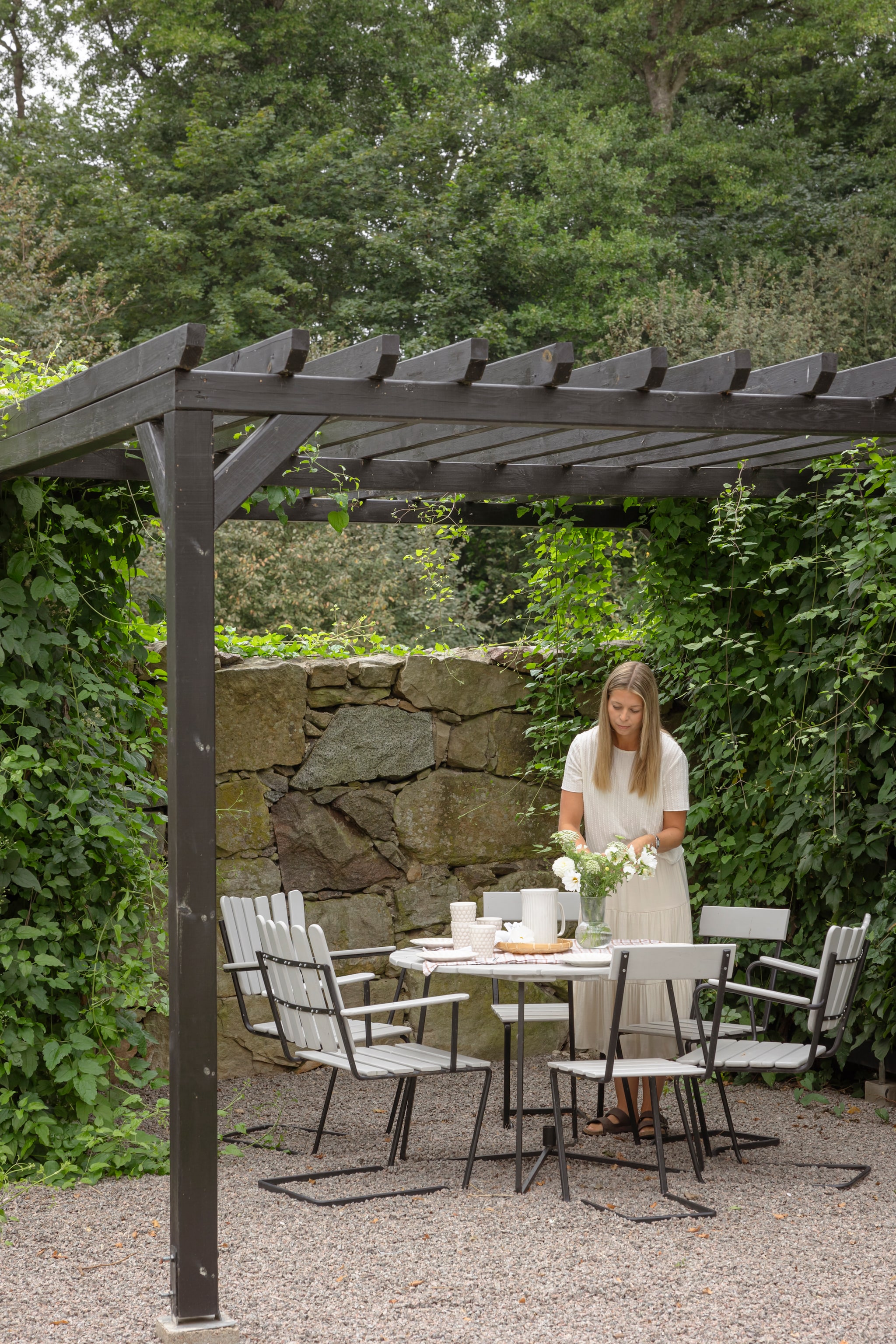 Pergola zelfgebouwd. Tafel en stoelen erfstukken van oma. vtwonen Landelijk 06-2026 | styling Anna Bjelkholm | fotografie Anna Karlsson