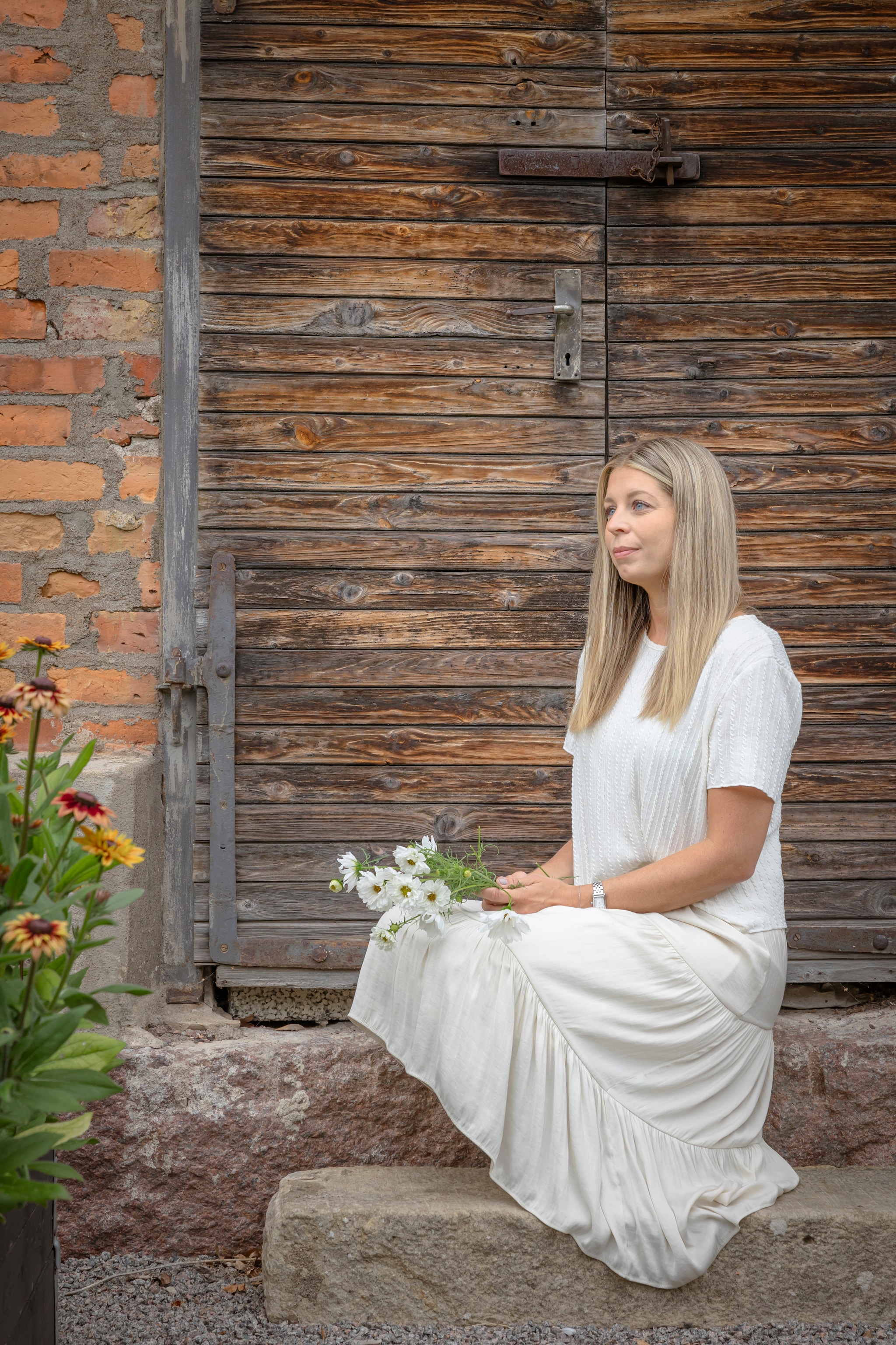 Julia voor de originele deur van de oude melkveehouderij. vtwonen Landelijk 06-2026 | styling Anna Bjelkholm | fotografie Anna Karlsson