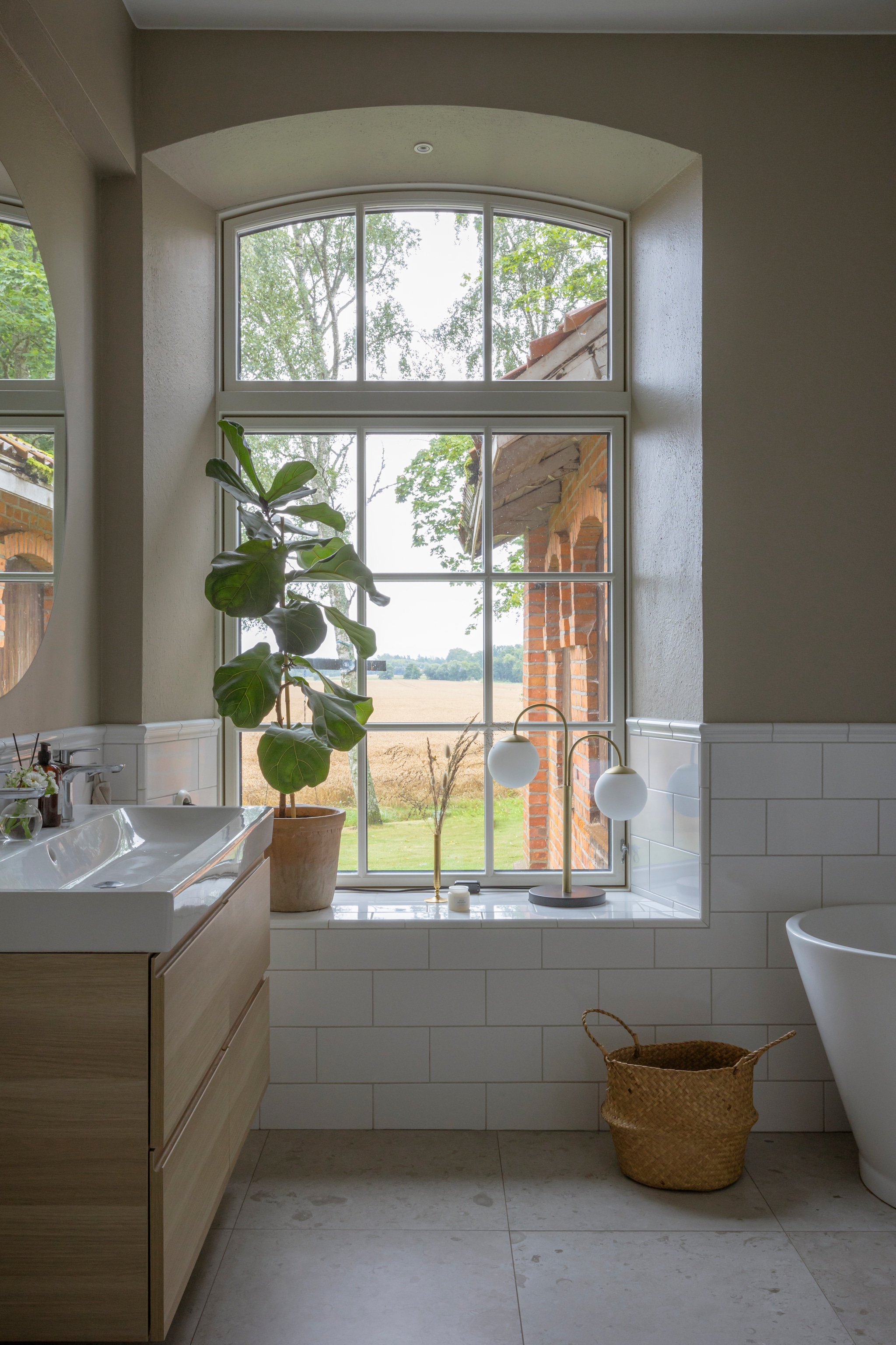 Muurverf Sand Beige van Jotun. Vloertegels Sand van Bricmate. Wandtegels Kakelexperten. Mand, Wastafelmeubel en spiegel Ikea. Pot en plant Gekås. Bollamp Globen Lighting. vtwonen Landelijk 06-2026 | styling Anna Bjelkholm | fotografie Anna Karlsson