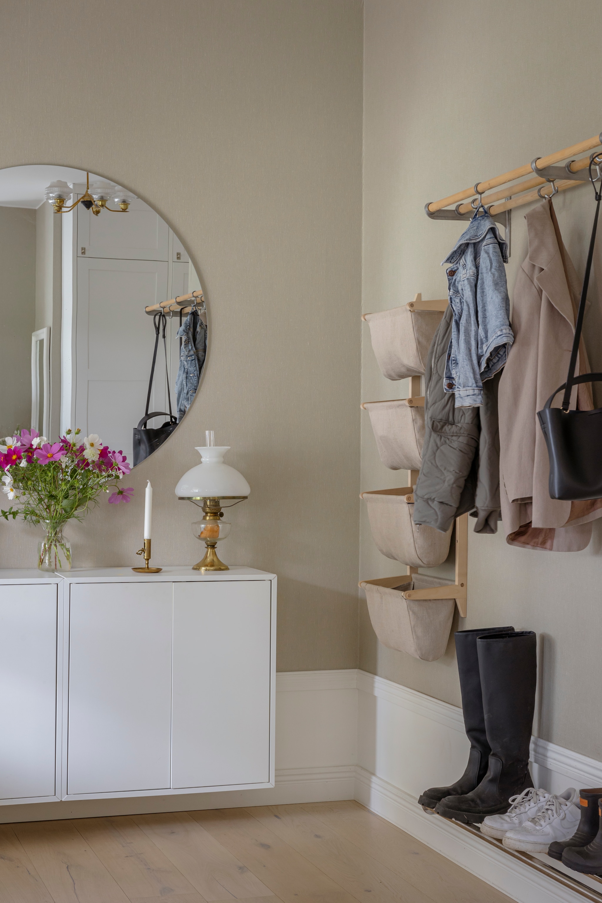Behang Linen Beige 4315 van Boråstapeter. Vloer gewit eiken van Bjelin. Spiegel en kast Eket van Ikea. Vaas Lilla Stenhuset. Lamp, kandelaar en kapstok vlooienmarkt. Manden Norrgavel. vtwonen Landelijk 06-2026 | styling Anna Bjelkholm | fotografie Anna Karlsson