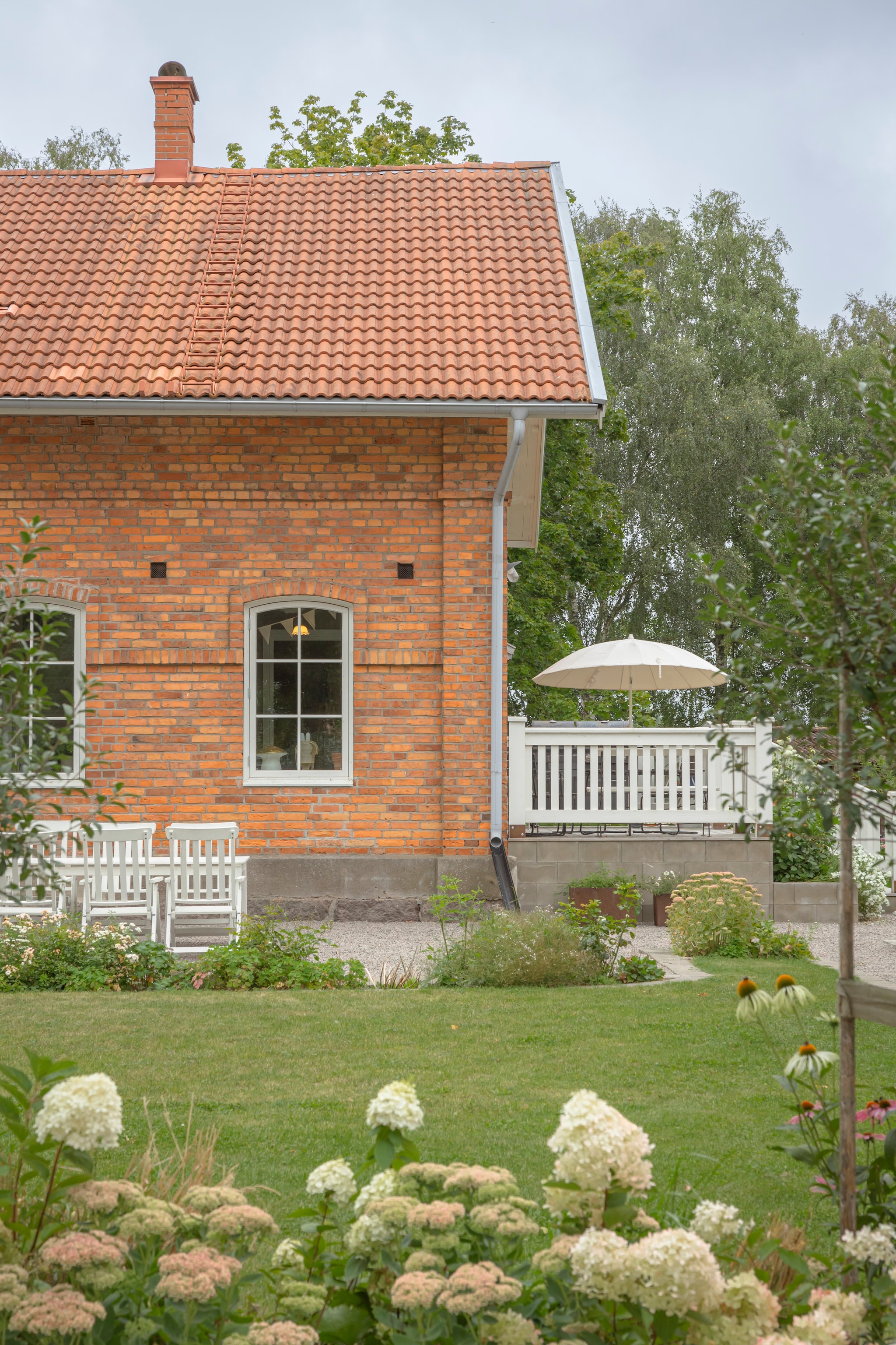Tafel, stoelen en parasol Ikea. Planten hortensia, sedum en zonnehoed. vtwonen Landelijk 06-2026 | styling Anna Bjelkholm | fotografie Anna Karlsson