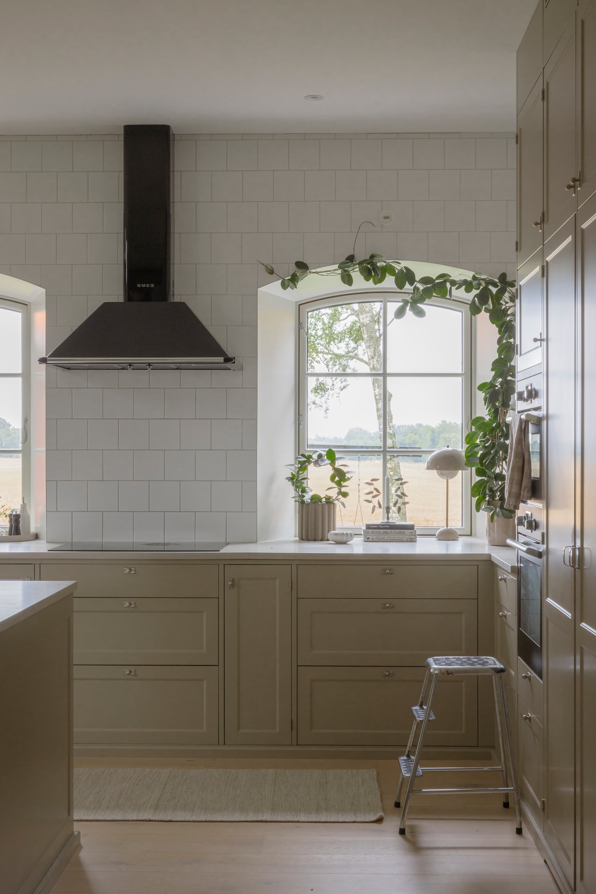 Vloer gewit eiken van Bjelin. Vloerkleed Bauhaus. Ramen Wsg Projects. Keuken Metod van Ikea. Fronten Shaker van Järfälla Kök. Handgrepen Beslag Design. Aanrechtblad laminaat decor White pine van Marbodal. Kraan Mora Armatur. Wandtegels Kakeldax. Afzuigkap Kt90ble van Smeg. Lamp Flowerpot van &Tradition. Keukentrap tweedehands. vtwonen Landelijk 06-2026 | styling Anna Bjelkholm | fotografie Anna Karlsson
