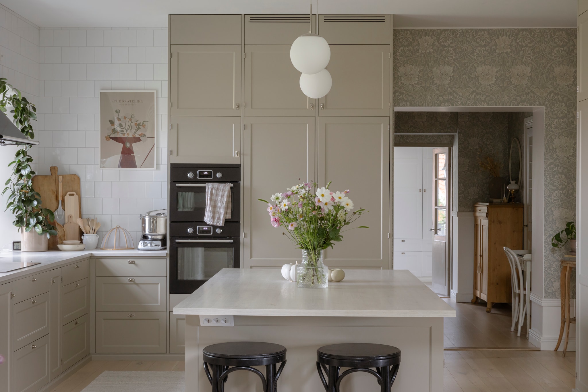 Keuken Metod van Ikea. Fronten Shaker van Järfälla Kök. Handgrepen Beslag Design. Afzuigkap kt90ble van Smeg. Hanglampen Ellos. Houten snijplanken vintage. Pot met pollepels en barkrukken vlooienmarkt.  vtwonen Landelijk 06-2026 | styling Anna Bjelkholm | fotografie Anna Karlsson