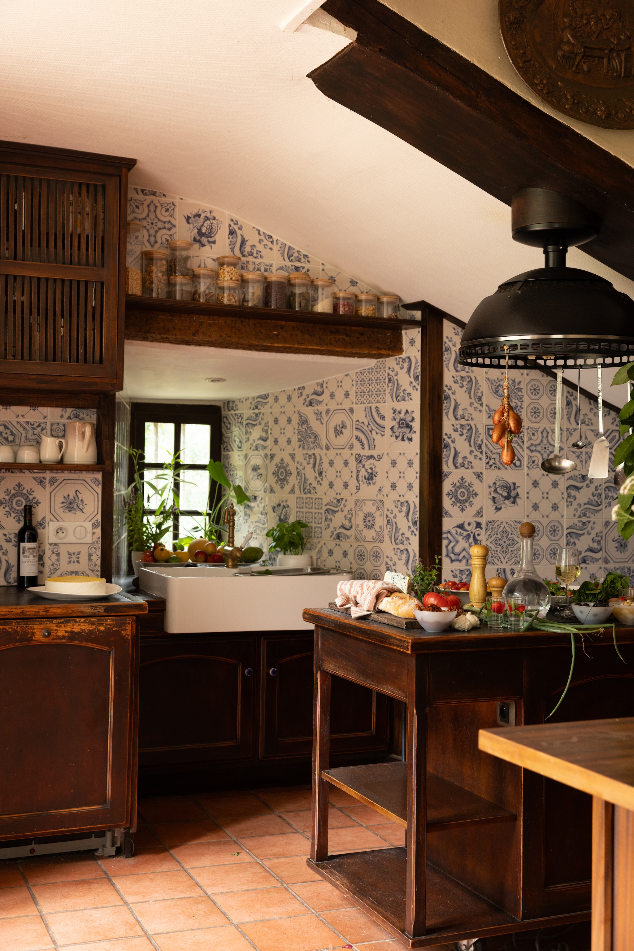 Op maat gemaakte keuken door vorige bewoners. Voorraadpotten Dille & Kamille. Servies brocante.   vtwonen Landelijk 06-2026 | styling Ilona Jongepier | fotografie Dana van Leeuwen