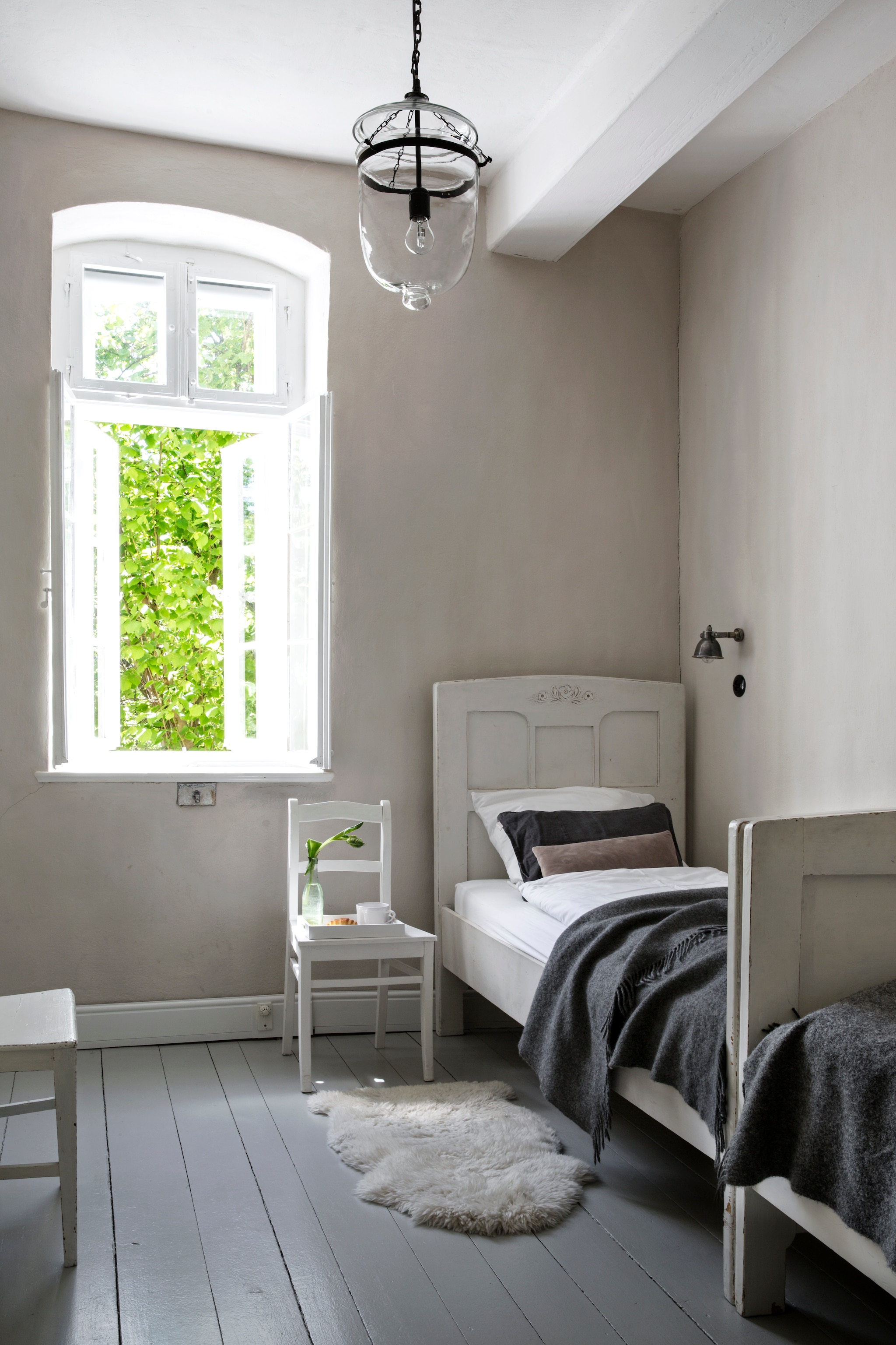 Bed Old Basics. Wandlamp Loberon. Beddengoed Fbf bed&more. Hanglamp Loberon. Op de muur kalkverf zelf gemengd met ecologisch pigment, beide Kreidezeit. Vloerverf Disbon 404 van Caparol, gemengd in de oorspronkelijke kleur van de vloer. vtwonen Landelijk 06-2026 | styling Miriam Hannemann | fotografie André Reuter