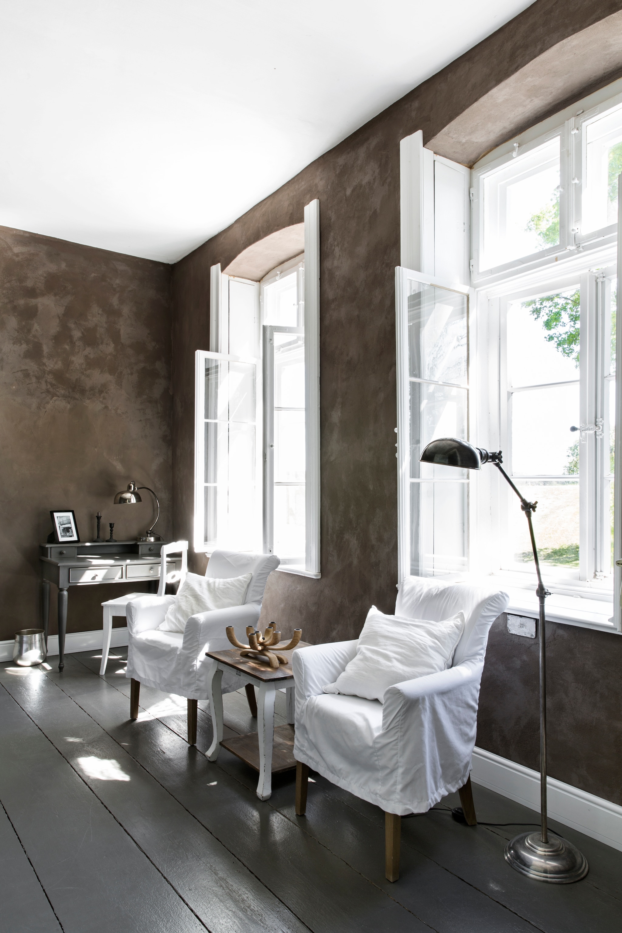 Zitje in de slaapkamer. Fauteuils, bijzettafel en vloerlamp Loberon. Bureau en bureaulamp Caro-Möbel. Op de muur kalkverf zelf gemengd met ecologisch pigment, beide Kreidezeit. vtwonen Landelijk 06-2026 | Styling Miriam Hannemann | Fotografie André Reuter