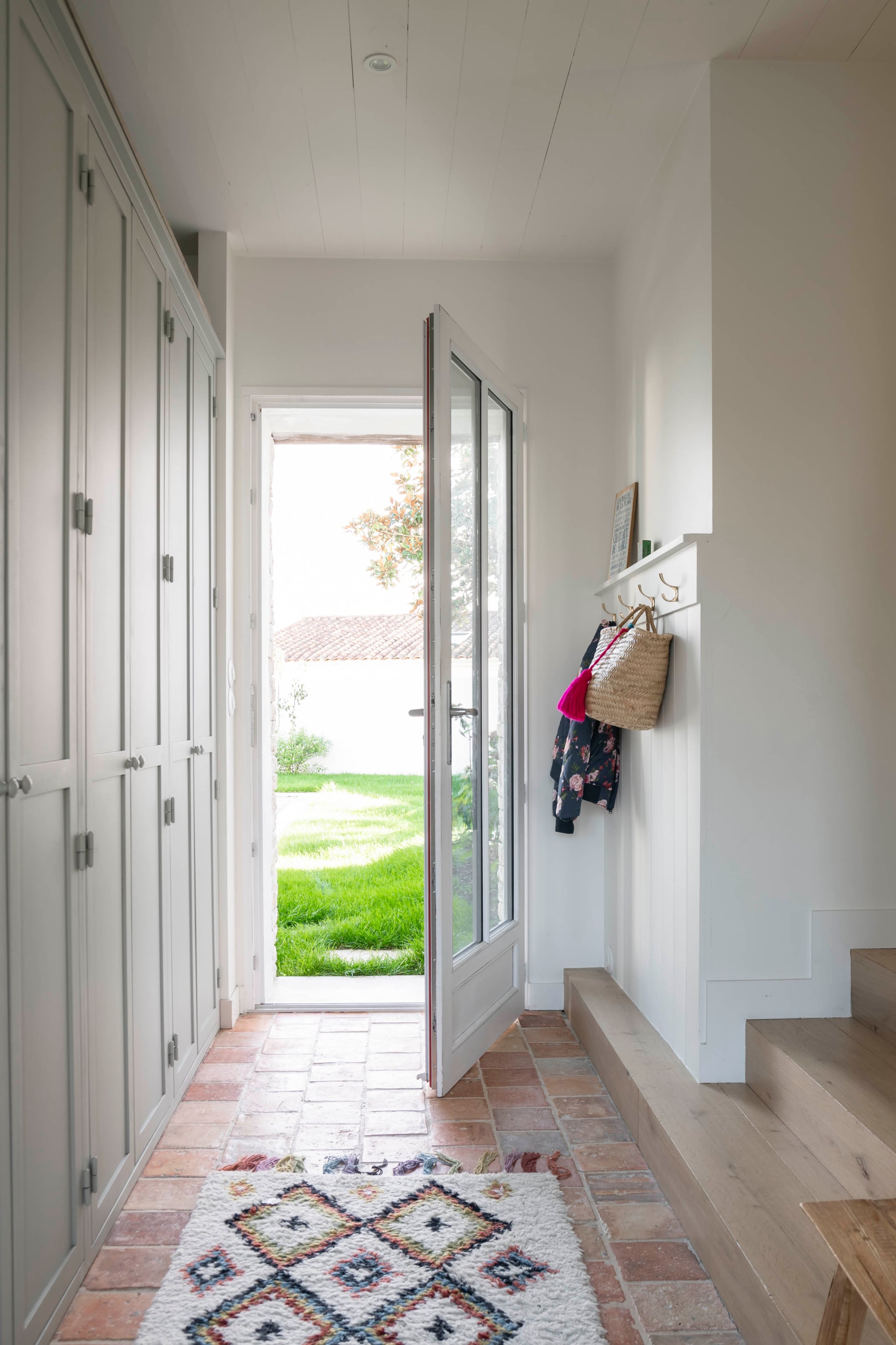 Berber vloerkleed uit Marokko. Kapstok Zara Home. Inbouwkasten gemaakt door lokale meubelmaker Pia Île de Ré. vtwonen Landelijk 06-2026 | styling Amandine Berthon | fotografie Julien Fernandez | productie Amandine & Jules