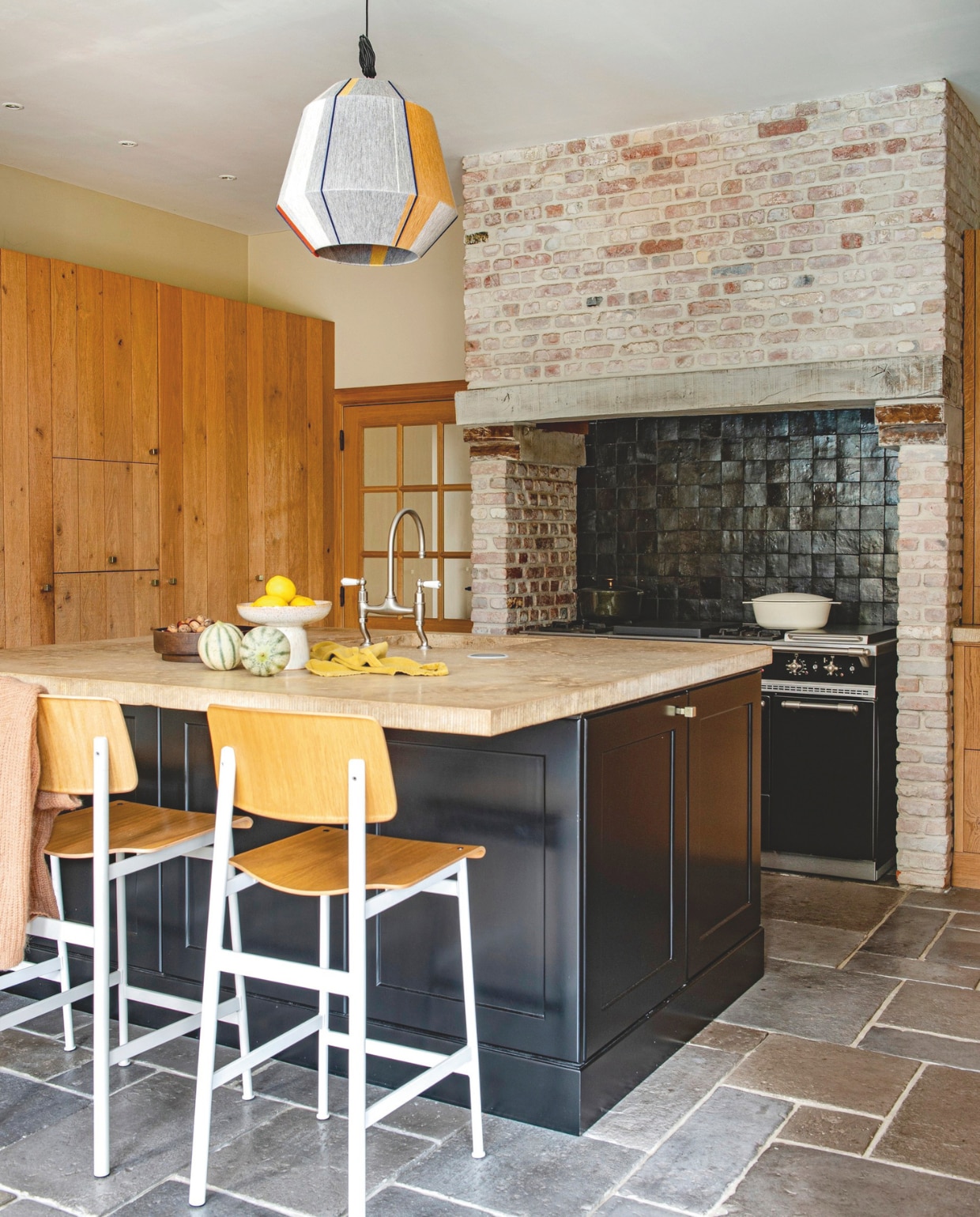 Oven Lacanche. Barstoelen Muuto. Tegelvloer Castle stones. Hanglamp Hay. Schaal H&m home. Fruitschaal Bloomingville. vtwonen landelijk 03-2026 | styling Katleen Willaert | fotografie Caroline Coehorst