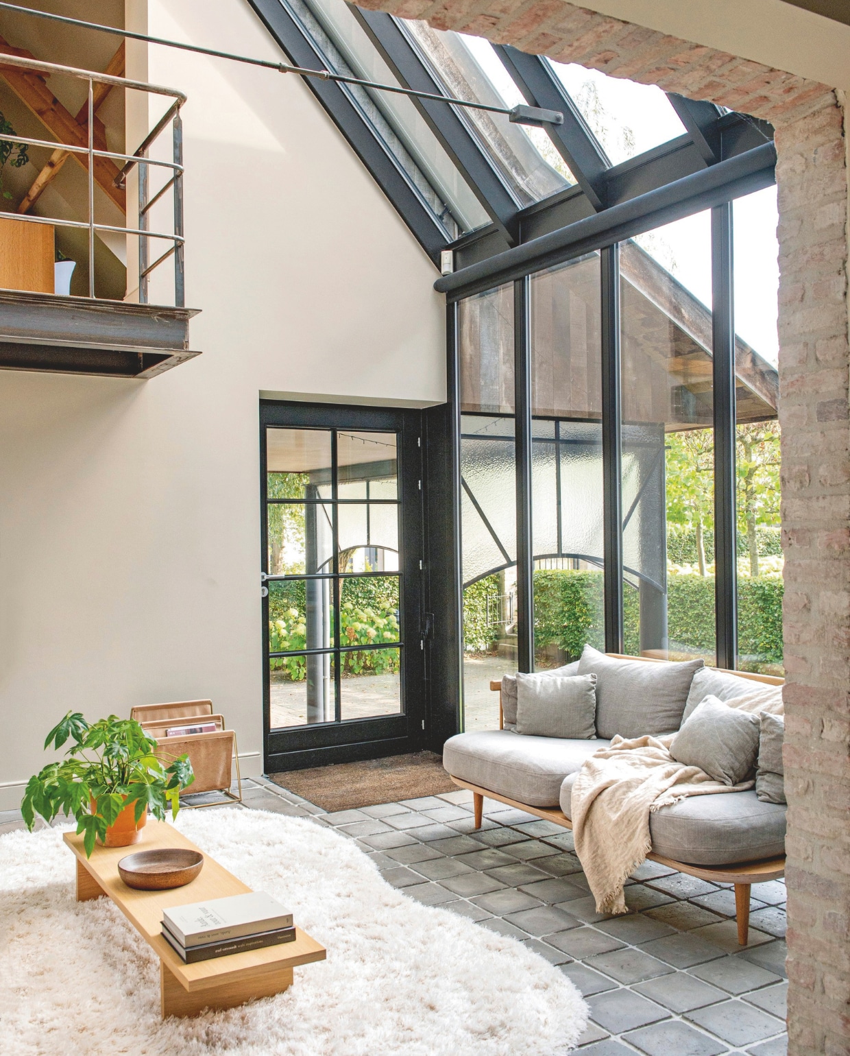 Muurkleur Buttercream Beige, gemengd bij Colora. Salontafel Kave Home. Schaal vintage. Plantsoort Fatsia Japonica. Pot Hema. Krantenhouder Quvio. Bank &Tradition. vtwonen landelijk 03-2026 | styling Katleen Willaert | fotografie Caroline Coehorst