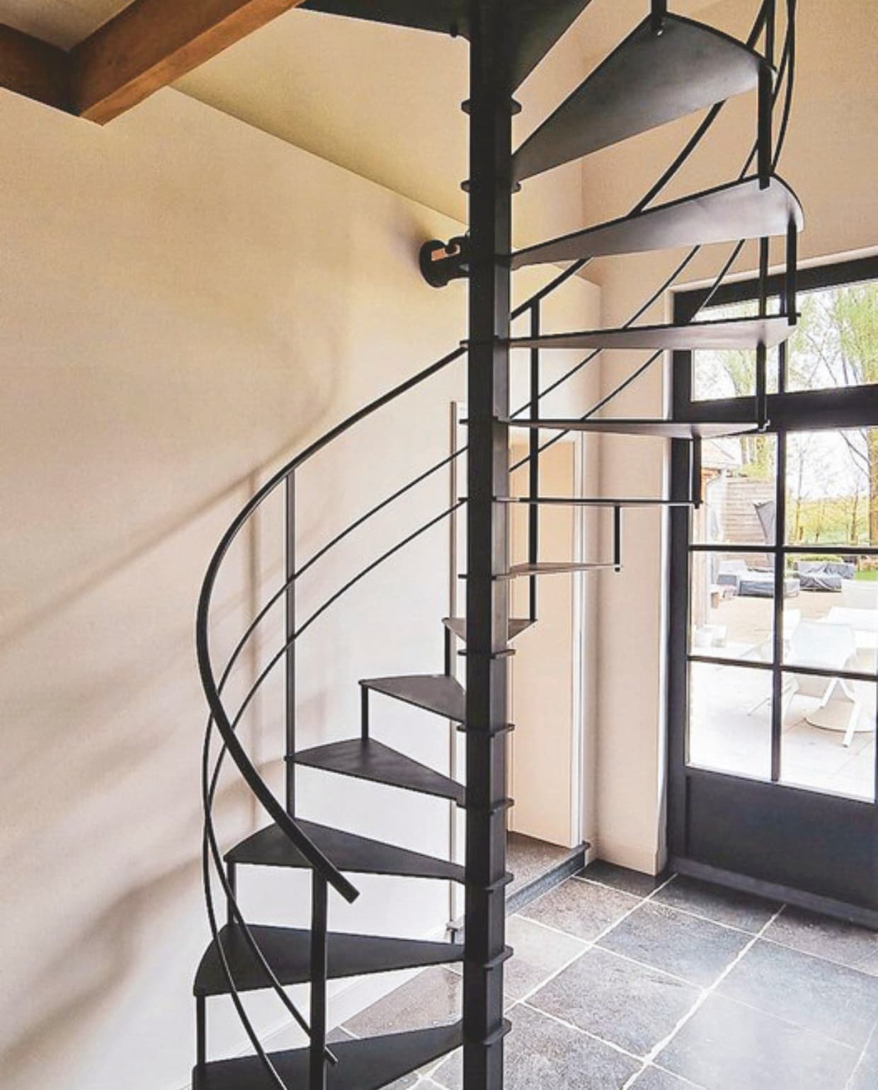 Spira wenteltrap Circle Steel, staal, maatwerk, prijs op aanvraag (spira.be). vtwonen landelijk 03-2026 | styling Katleen Willaert | fotografie Caroline Coehorst