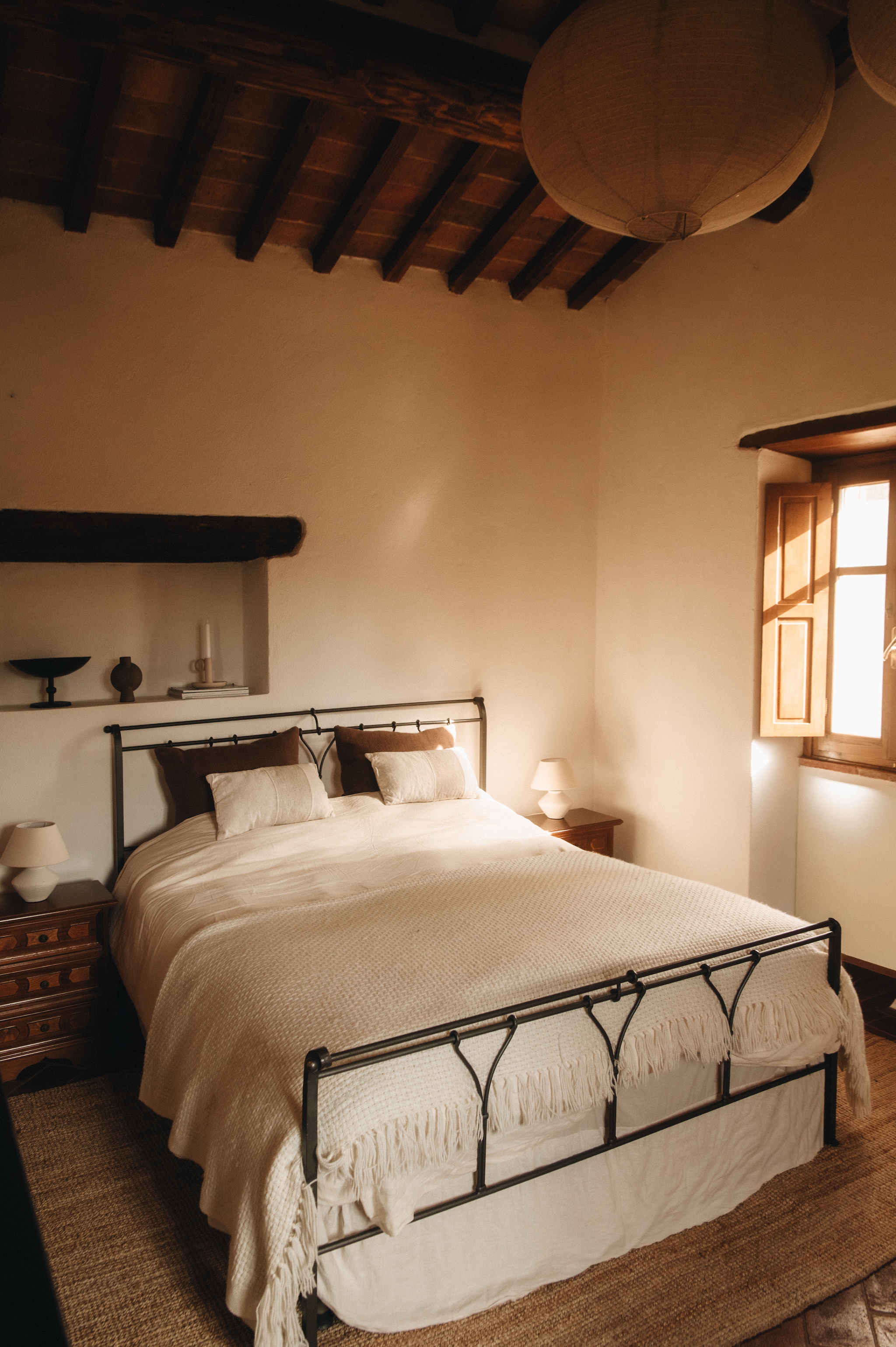 De gastenslaapkamer met antiek bed en antieke nachtkastjes. Kussens, sprei, bedlampen en plafondlamp Zara Home. Vaasje 101 Copenhagen. Vloerkleed Ikea. vtwonen landelijk 6-2026 | fotografie Jeroen Noordzij