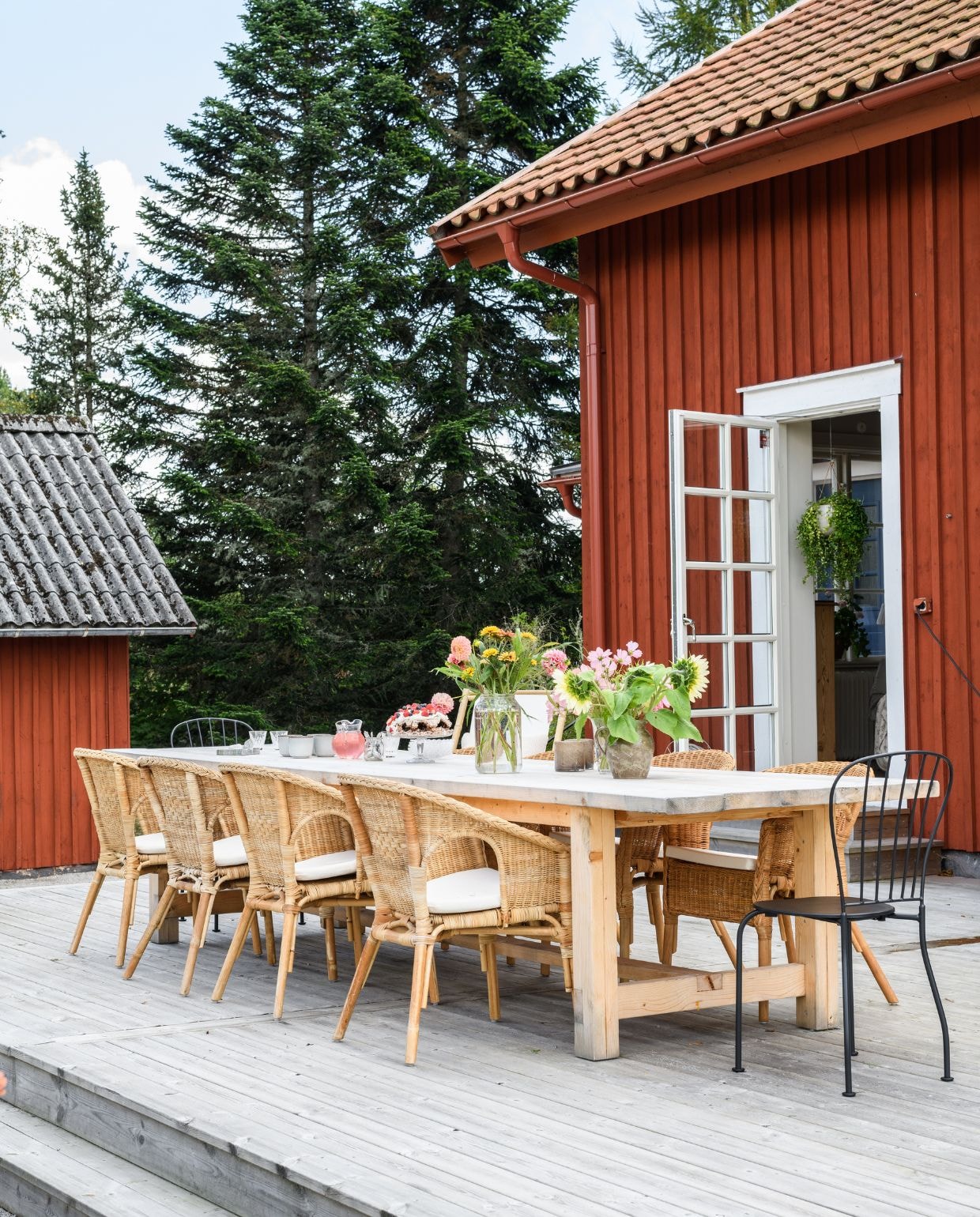 Houten tafel zelfgemaakt door Johannes. Rotan stoelen en zwarte metalen stoelen Ikea. Bloemen uit de tuin. Vazen tweedehands.