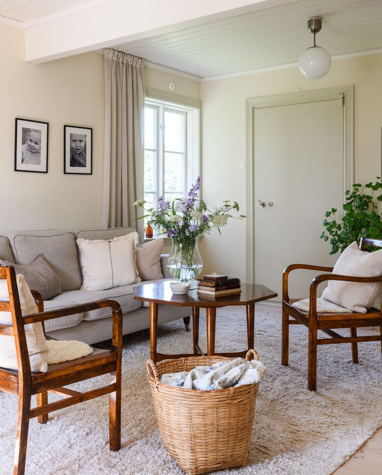 Linnen gordijnen Hemtex. Fauteuils en salontafel tweedehands. Linnen kussens Rusta en H&m Home. Plafondlamp Ikea. Vloerkleed Trendcarpet. Bloemen uit eigen tuin: ridderspoor, Ammi majus en siergras. Muren geschilderd metlijnolieverf NCS 1104-Y24R van Engwall & Claesson. Houtwerk en deuren geschilderd met lijnolieverf 30% Tarwegrijs vanOttosson. vtwonen Landelijk 03-2026 | fotografie Rebecca Martyn