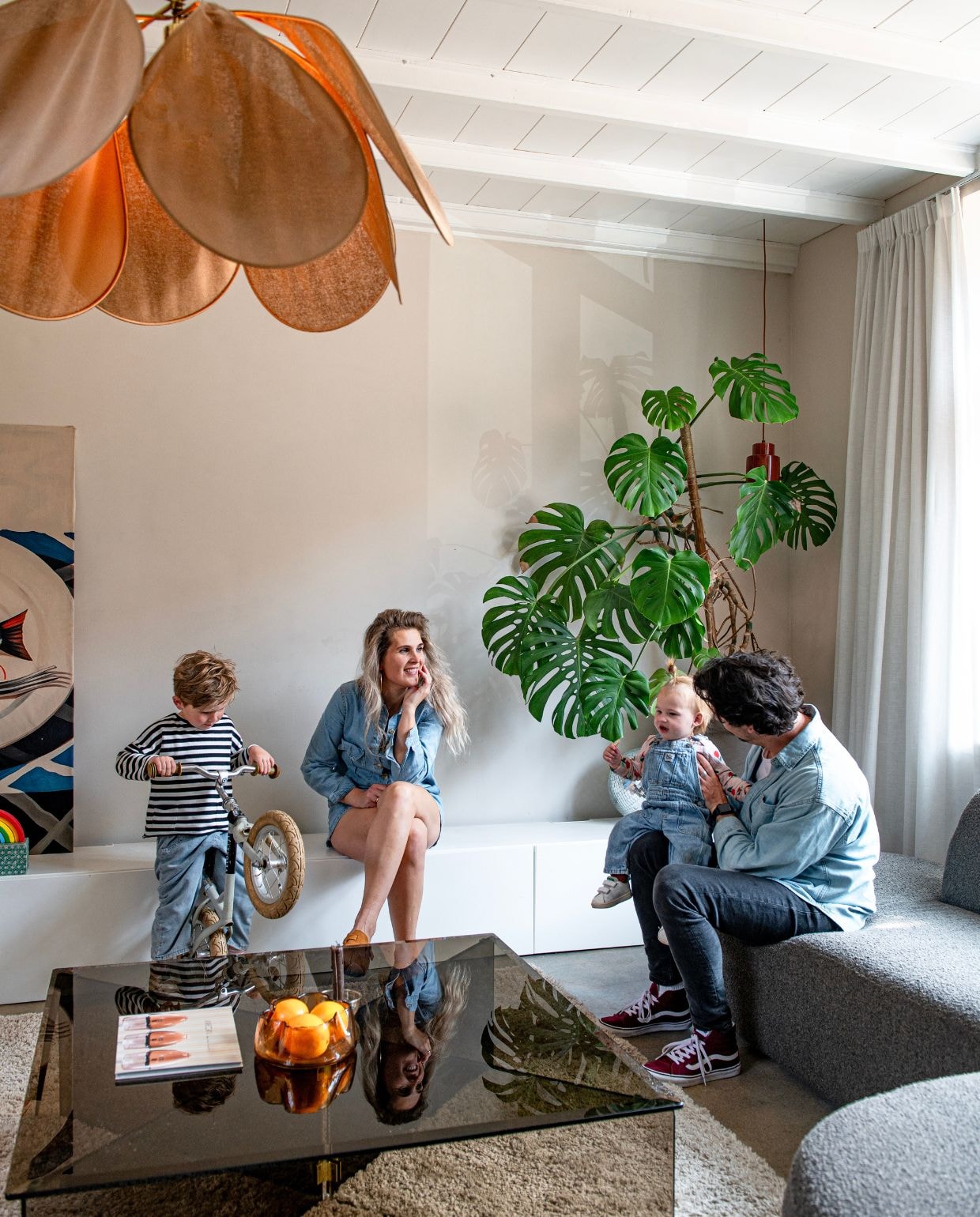 Bank en vloerkleed Wehkamp. Plafondlamp Georges Store. Salontafel Marktplaats. Kussens, kandelaar, vaas en rode lamp Karwei. Plantenpot Hornbach. Schaal Light & Living. Gordijnen Kwantum. De schommel was een cadeau. Discobal Hema. vtwonen 03-2026 | fotografie Caroline Coehorst