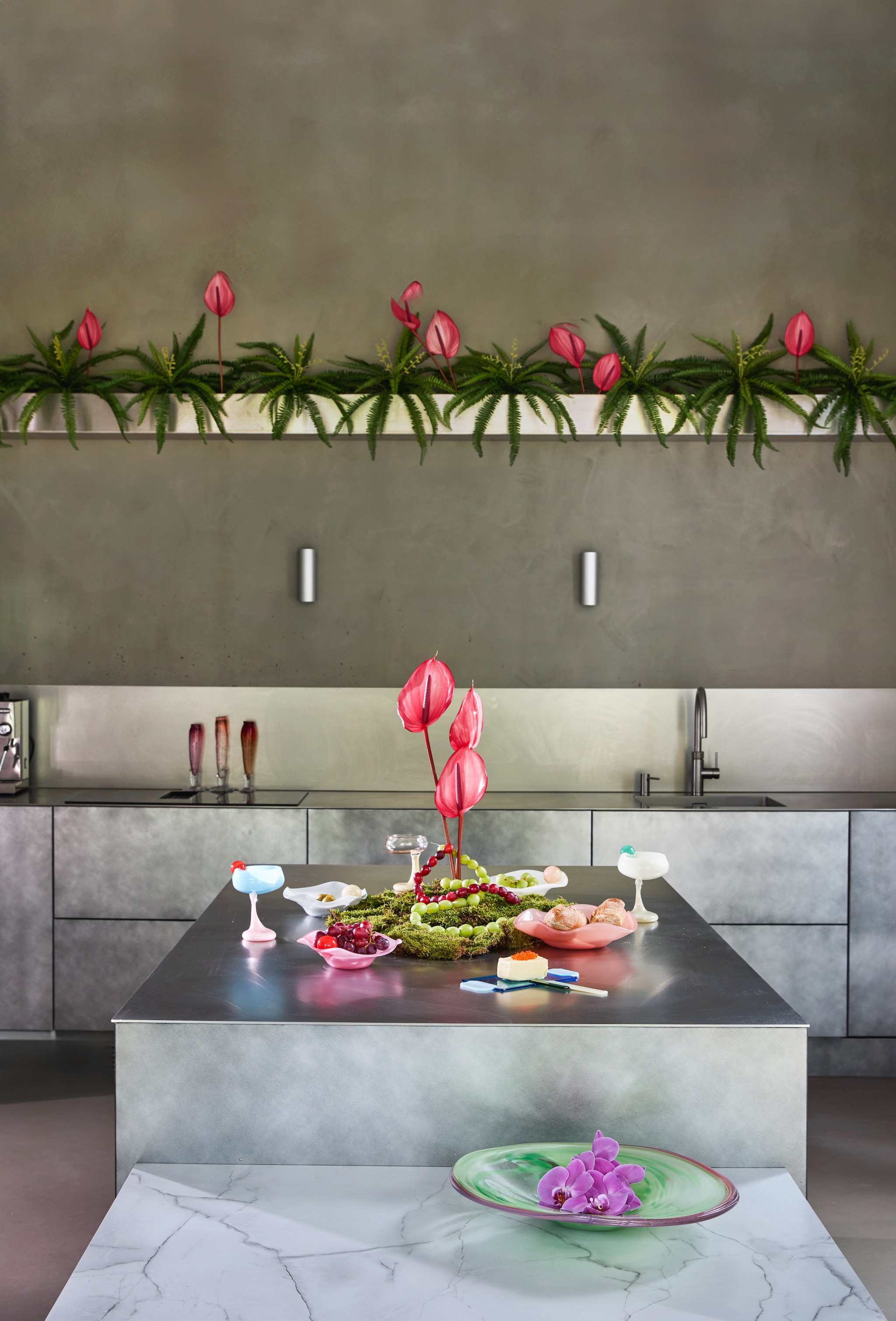 Sandra Keja Planken schaal, glas, groen en lila € 899,- (sandrakejaplanken-noun.com). Meester in bloemen bloemen anthurium, prijs op aanvraag (meesterinbloemen.nl). Fleur Peters boterplank en mes Gems Butter, glas, blauw en groen € 55,- (studiofleurpeters.nl). Helle Mardahl schaal The Deep Plate, glas, rubarb € 220,-, kommen The Bowl with a twist, glas, creamy melon, coconut en caramel apple, blueberry ice cream, set van 2 € 585,-, kom The Bowl with a twist, glas, chili red and pink € 365,-, cocktailglas The Signature Glass with a Twist, glas, spearmint, coconut, champagne € 430,-, cocktailglas The Signature Glass with a Twist, glas, grapefruit, blue jelly, milky rose € 430,-, cocktailglas The Signature Glas, glas, caramel apple € 360,- (hellemardahl.com). Bernard Heesen glazen Flûtes, glas, paars, rood en roze, per stuk € 45,- (deoudehorn.com). vtwonen 06-2026 | styling Kelly van Gendt | fotografie Peggy Janssen
