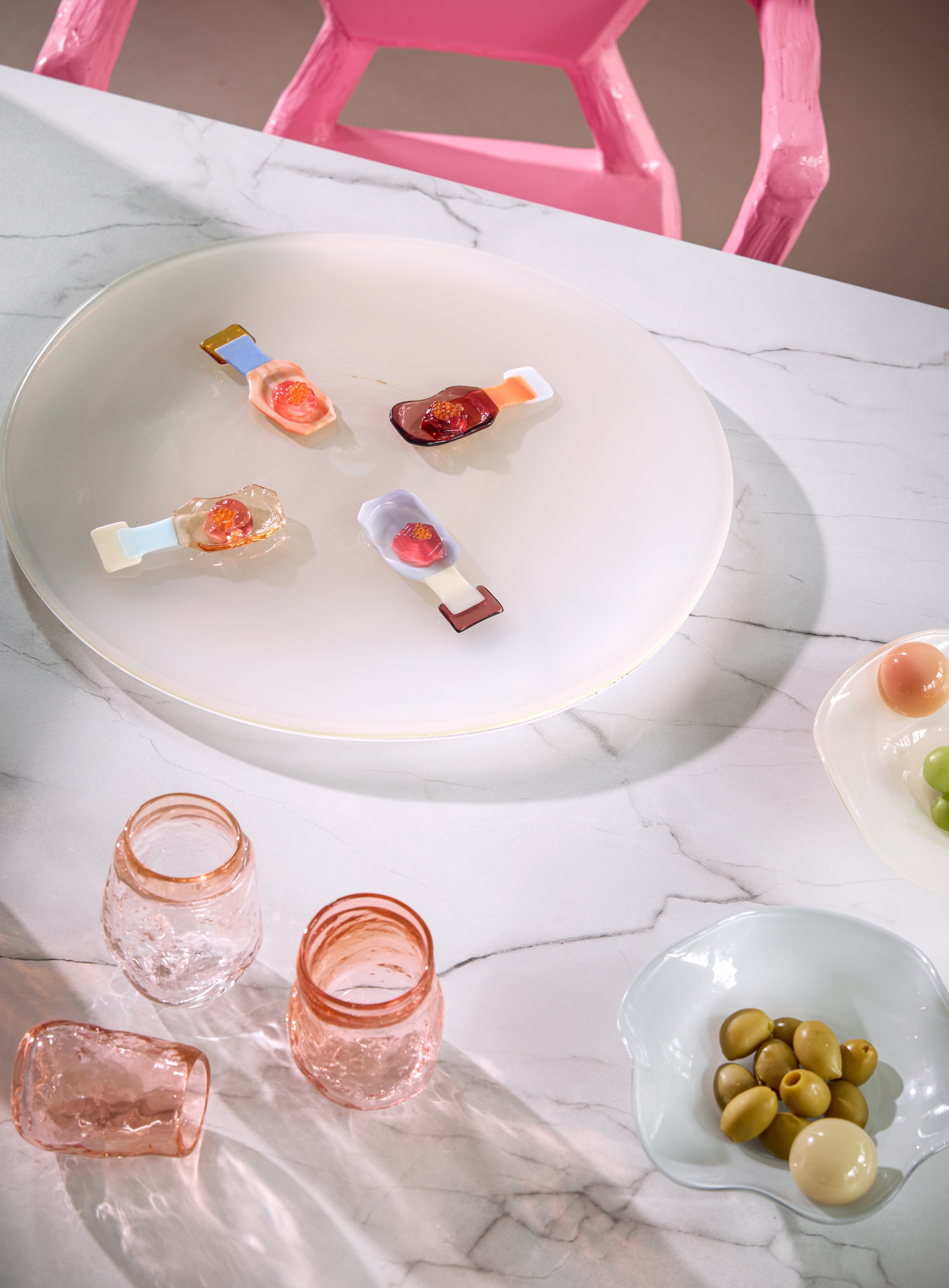 Helle Mardahl kommen The Bowl with a twist, glas, creamy melon, coconut en caramel apple, blueberry ice cream, set van 2 € 585,- (hellemardahl.com). Bernard Heesen glazen, glas, perzik, per stuk € 30,- (deoudehorn.com). HKliving stoel Medaillon, ontwerp Teun Zwets, sunkai hout, roze, 64x74x97 cm (bxdxh) € 595,- (hkliving.com). Fleur Peters amuselepels Sugar, glas, set van 4 € 55,- (studiofleurpeters.nl). Overig privébezit. vtwonen 06-2026 | styling Kelly van Gendt | fotografie Peggy Janssen
