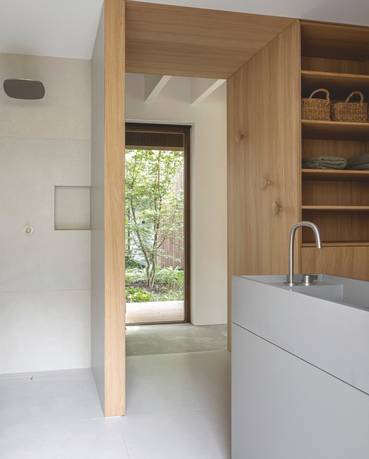 De maatwerkkast is bekleed met eikenfineer en werd gemaakt door meubelmaker Luc Schoenmakers. Wandtegels Blend Chalk White van Piet Boon. Soortgelijke manden in kast Zara Home. vtwonen design 02-2026 | fotografie Tim Van de Velde