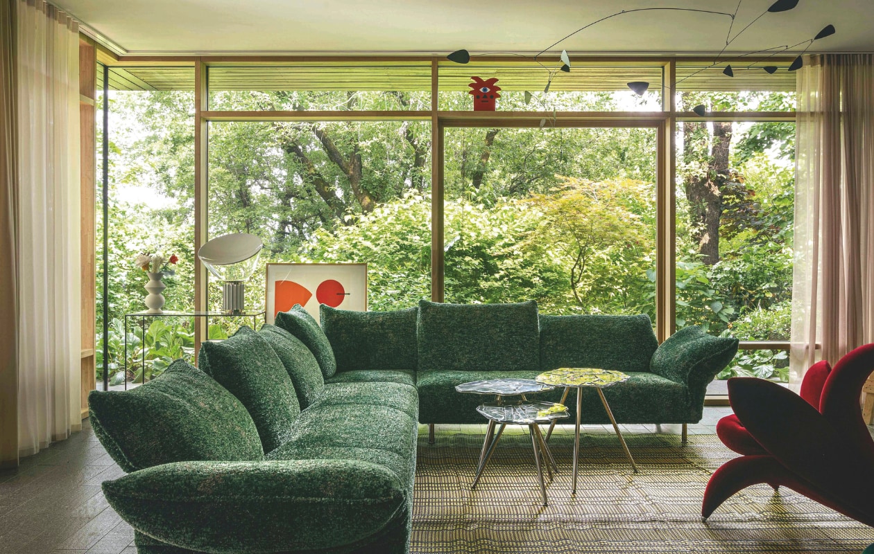 Bank Standard en bijzettafels Brasilia van Edra. Tafellamp Taccia van Flos. Afrikaans vloerkleed handgemaakt van plastic afval. Mobile ontworpen door Spaanse artiesten, geïnspireerd op het werk van Calder. Rode vaas Oggian Red Palm van Qeeboo. Kunstprint gekocht bij Fondation Maeght in Saint-Paul-de-Vence. vtwonen design 02-2026 | fotografie Mattia Aquila