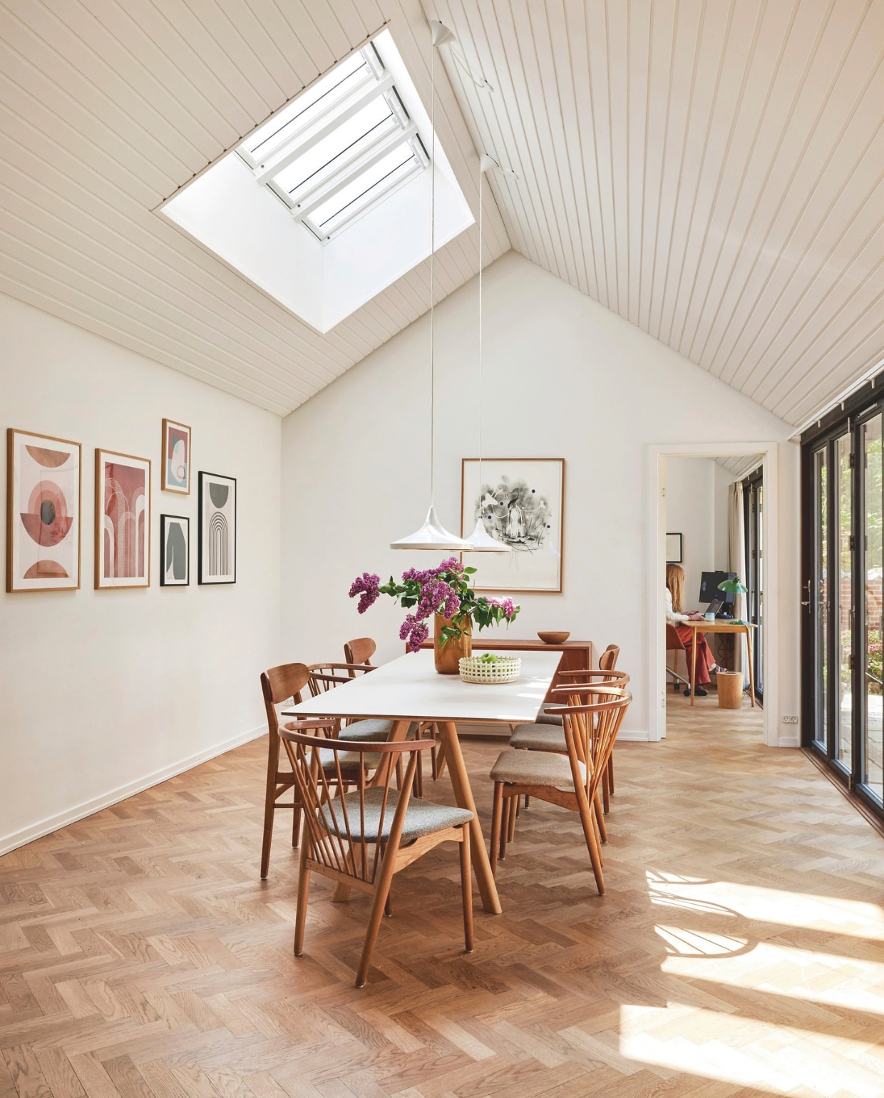 Eettafel Hay, stoelen Sibast Furniture, plafondlampen Tom Dixon, posters Desenio, zwart-witte litho Kathrine Ærtebjerg, vaas H&M Home, gevlochten schaal Ferm Living. vtwonen 06-2024 | fotografie Christina Kayser Onsgaard | styling Rikke Graff Juel