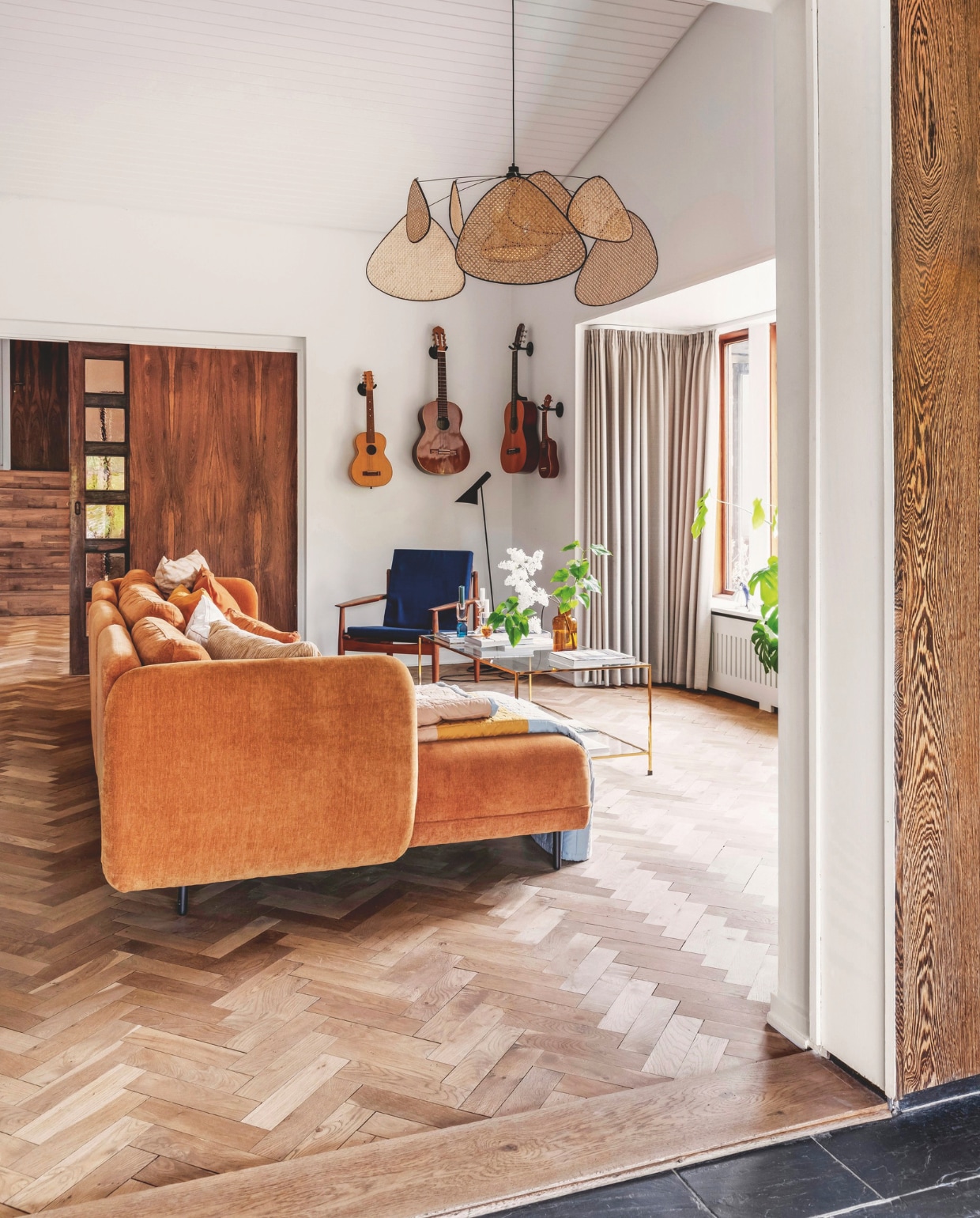 Stenen terras aangelegd door de vorige bewoners, tuintafel Fermob, stoelen Fdb Møbler, schapenvachten Ikea, tafelkleed Fabelab. De parketvloer is 75 jaar oud, bank Sofacompany, lamp Market Set, oude gitaren van Michaela, salontafel Ellos, kandelaars C’est Bon, vaas H&M Home.