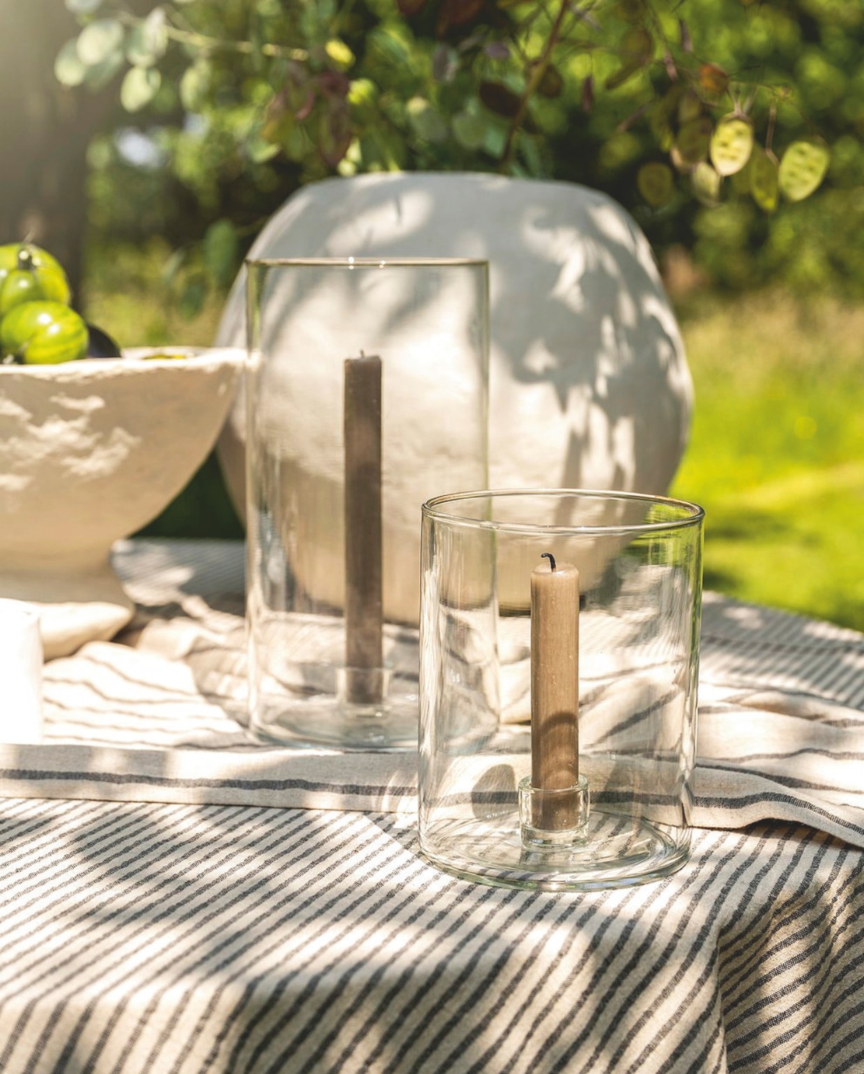 vtwonen kandelaar, glas, 12x15,5 cm (Øxh) € 22,95, vtwonen kandelaar, glas, 13x25cm (Øxh) € 29,95, vtwonen tafelkleed, katoen en linnen, blauw en wit, 250x150 cm (lxb) € 79,95. vtwonen landelijk 03-2025 | styling Sanne Ketelaar | fotografie Stan Koolen