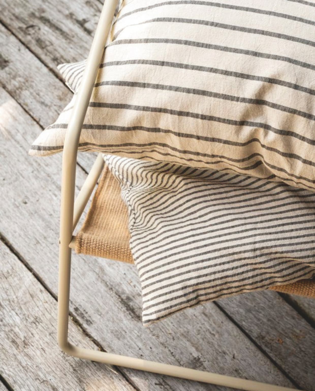 vtwonen poef, katoen en linnen, beige en grijs, 45x45x25cm (lxbxh) € 69,95, vtwonen sierkussen vierkant, katoen en linnen, beige en donkerblauw, 50x50 cm (lxb) € 44,95, vtwonen sierkussen rechthoek, katoen en linnen, beige en donkerblauw, 70x50 cm (lxb) € 59,95, vtwonen wijnglas, gerecycled glas € 14,95,vtwonen bijzettafel, metaal, wit en donkerblauw, 35,5x46 cm (Øxh) € 169,-,M.m.v. fermliving.com (fauteuil), shop.vtwonen.nl (mok met oor van vtwonen). Overig privébezit. vtwonen landelijk 03-2025 | styling Sanne Ketelaar | fotografie Stan Koolen