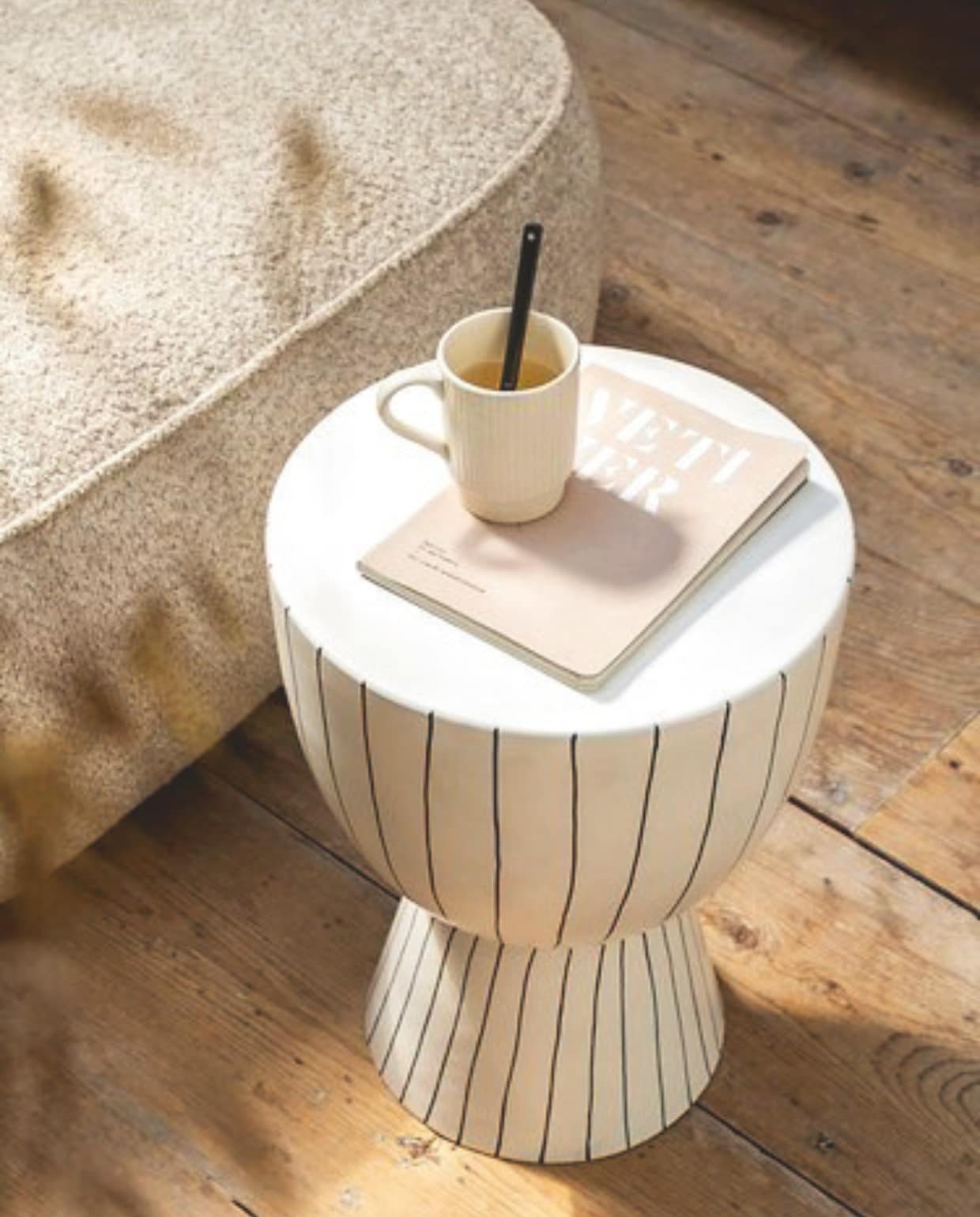 vtwonen poef, katoen en linnen, beige en grijs, 45x45x25cm (lxbxh) € 69,95, vtwonen sierkussen vierkant, katoen en linnen, beige en donkerblauw, 50x50 cm (lxb) € 44,95, vtwonen sierkussen rechthoek, katoen en linnen, beige en donkerblauw, 70x50 cm (lxb) € 59,95, vtwonen wijnglas, gerecycled glas € 14,95,vtwonen bijzettafel, metaal, wit en donkerblauw, 35,5x46 cm (Øxh) € 169,-,M.m.v. fermliving.com (fauteuil), shop.vtwonen.nl (mok met oor van vtwonen). Overig privébezit. vtwonen landelijk 03-2025 | styling Sanne Ketelaar | fotografie Stan Koolen