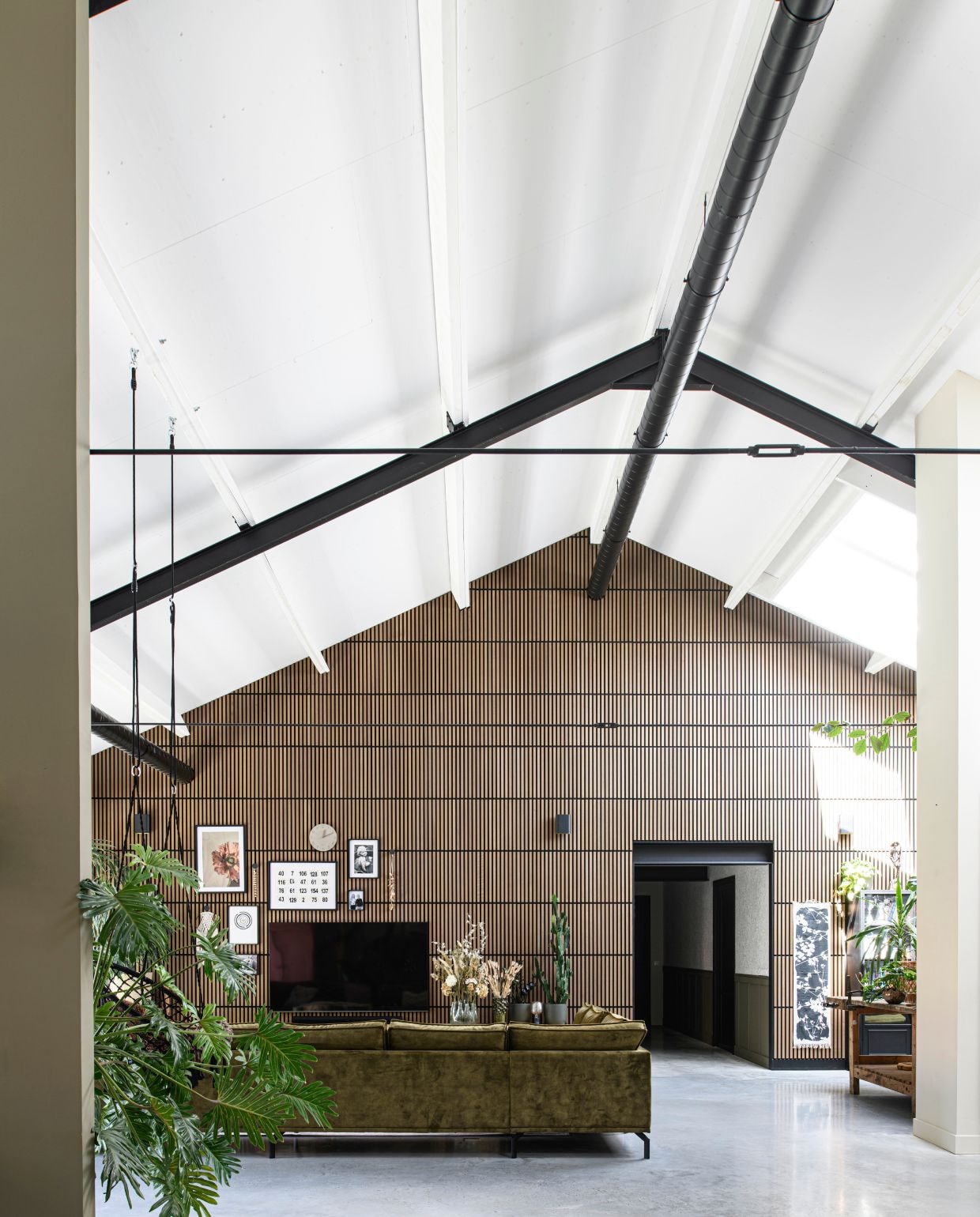 Wandpanelen Silentlines van Gamma. Fotolijsten en wandkleed Ikea. Vazen en boeketten Intratuin. Wandlampen Lucide Ovalis. vtwonen 03-2026 | styling Marit Saladini | fotografie Louis Lemaire