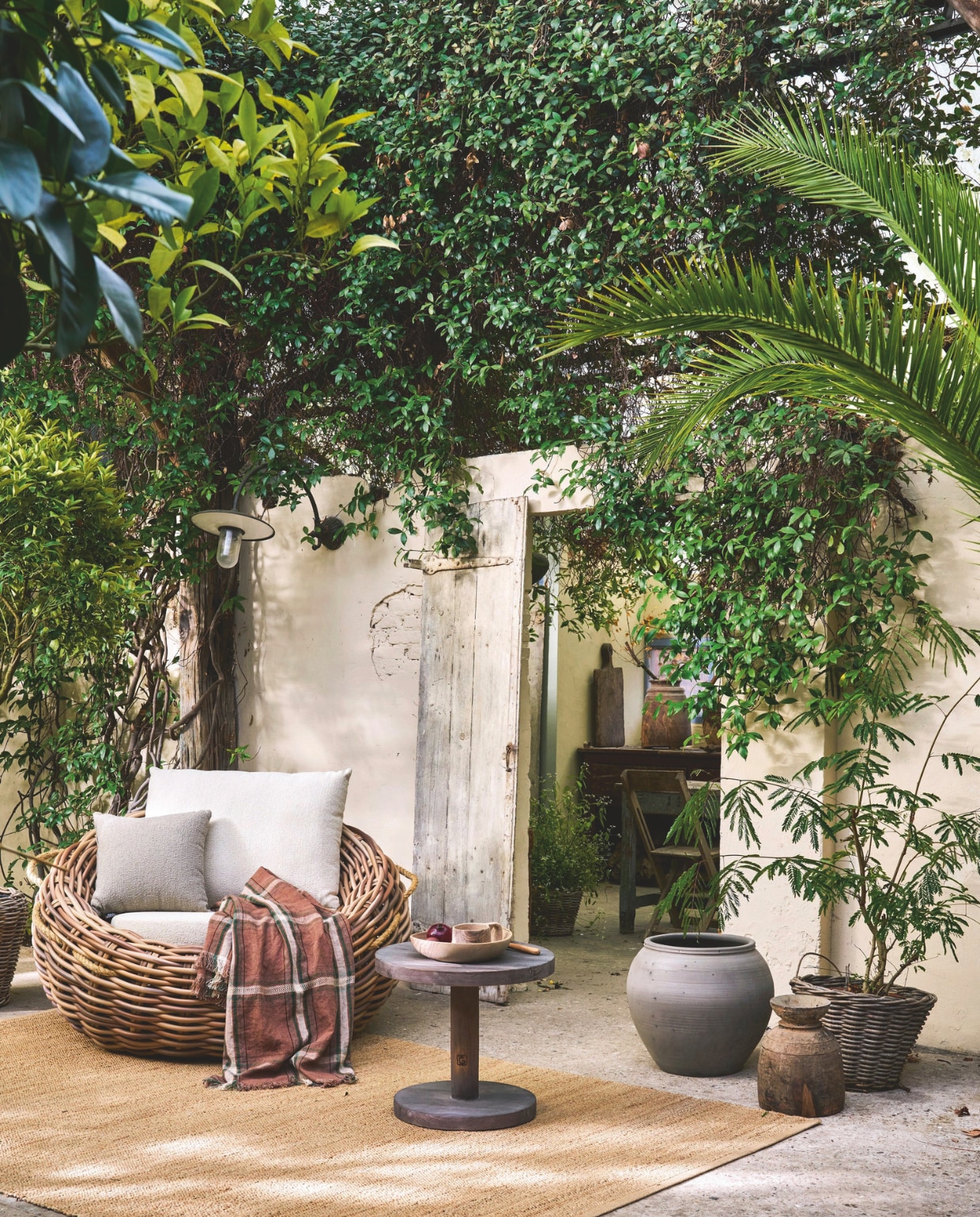 Apple Bee lounge tuinstoel Cocoon Boucle, kunststof biculair wicker, mokka, 130x78 cm (Øxh), kussens, bouclé wasbare stof, crème en taupe € 1339,- (applebee.nl), HKliving vloerkleed, jute, naturel, 340x240 cm (lxb)€ 329,- (shop.vtwonen.nl). ’t Achterhuis bijzettafel, vergrijsd hout, 50x50 cm (bxh) € 479,16, pot, riet vanaf € 194,81, pot, aardewerk, grijs € 133,10 (achterhuis.nl). Libeco doek Rowan piece de Lin, linnen, meerkleurig € 247,- (libecohomestores.eu). Household Hardware schaal, hout, bruin € 21,-, beker, walnoot, bruin € 49,50 (householdhardware.nl). Overig privébezit. vtwonen Landelijk 03-2026 | fotografie Jeroen van der Spek | styling Cleo Scheulderman