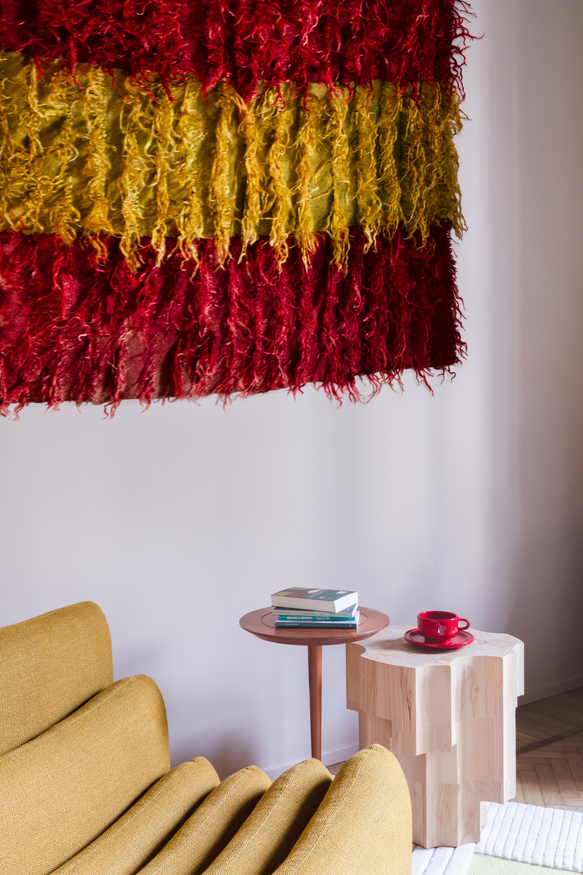 Fauteuil Additional System en bijzettafel Altar van Tacchini. Handgeknoopt Filikli-wandtapijt Altai. Vintage bijzettafel en kop en schotel via Gaiahomeproject. vtwonen Design 06-2026 | fotografie Monica Spezia